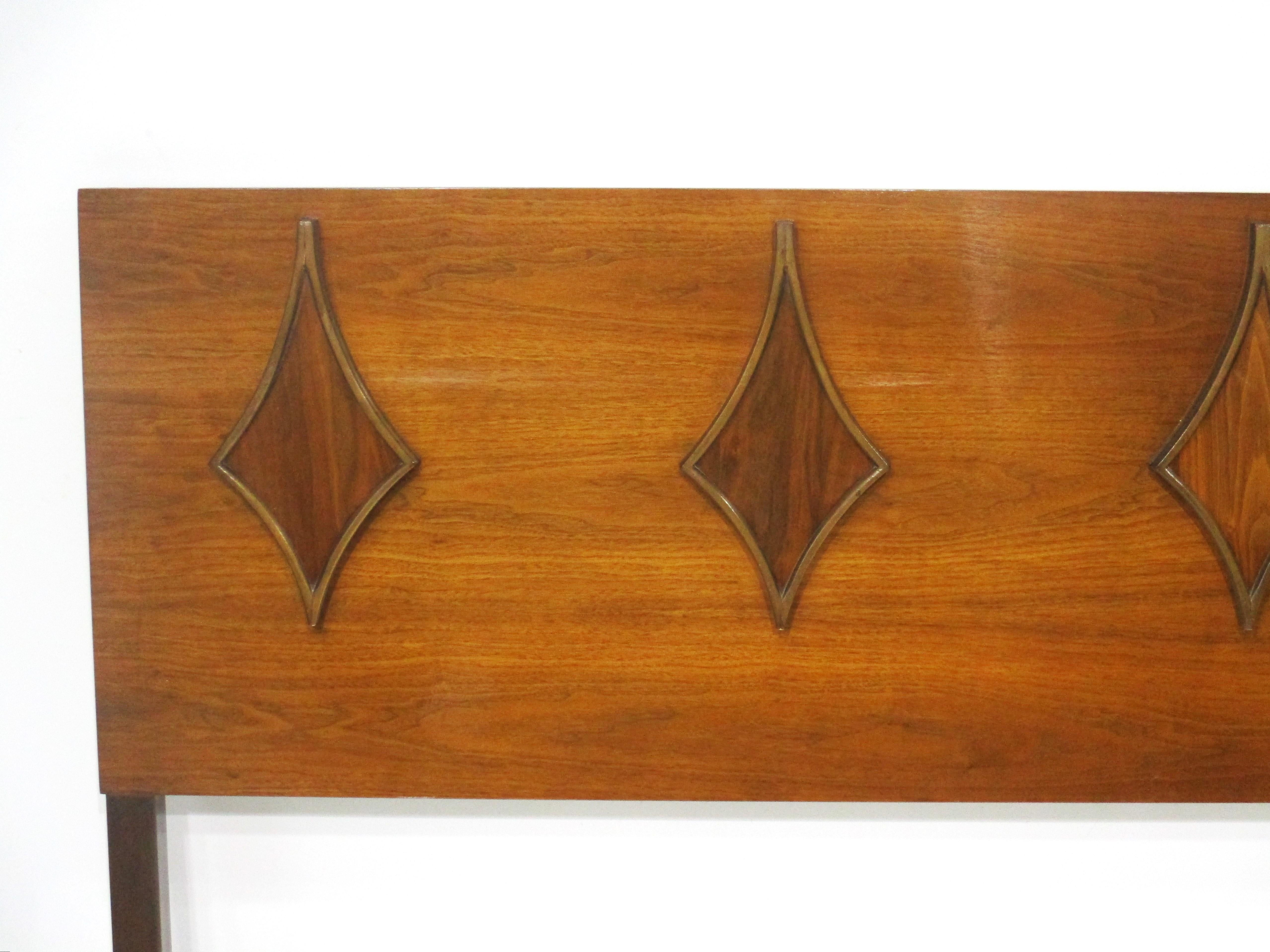 A Mid Century queen sized walnut headboard with sculptural diamond designs to the front . Manufactured and designed in the manner of the G Plan furniture company with a slight satin gloss finish making the piece rich and showing off the graining .