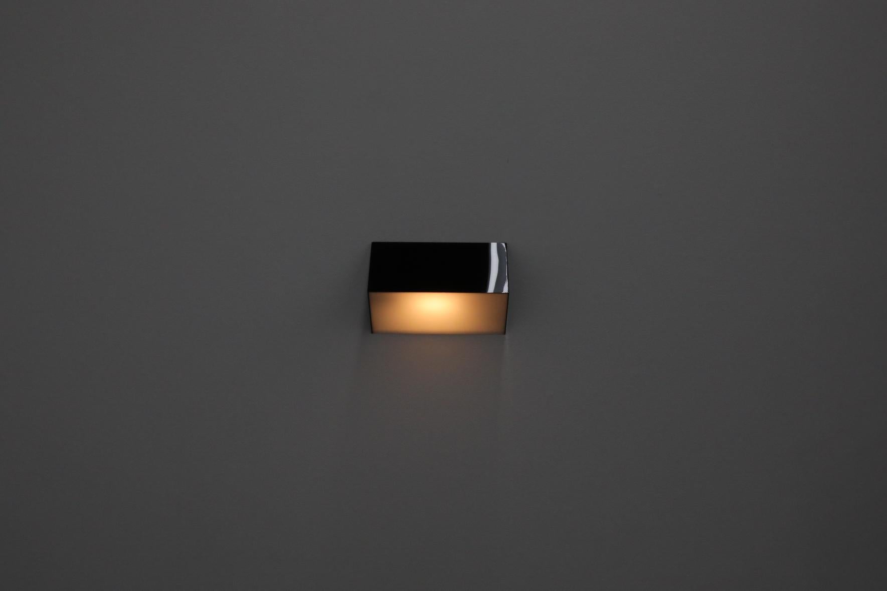 Subtly designed, stylish black and white triangular plexiglass wall sconce made in Holland by the acclaimed lighting manufacturer RAAK. In original condition with minimal wear. Also available in all white with black sides (please inquire).