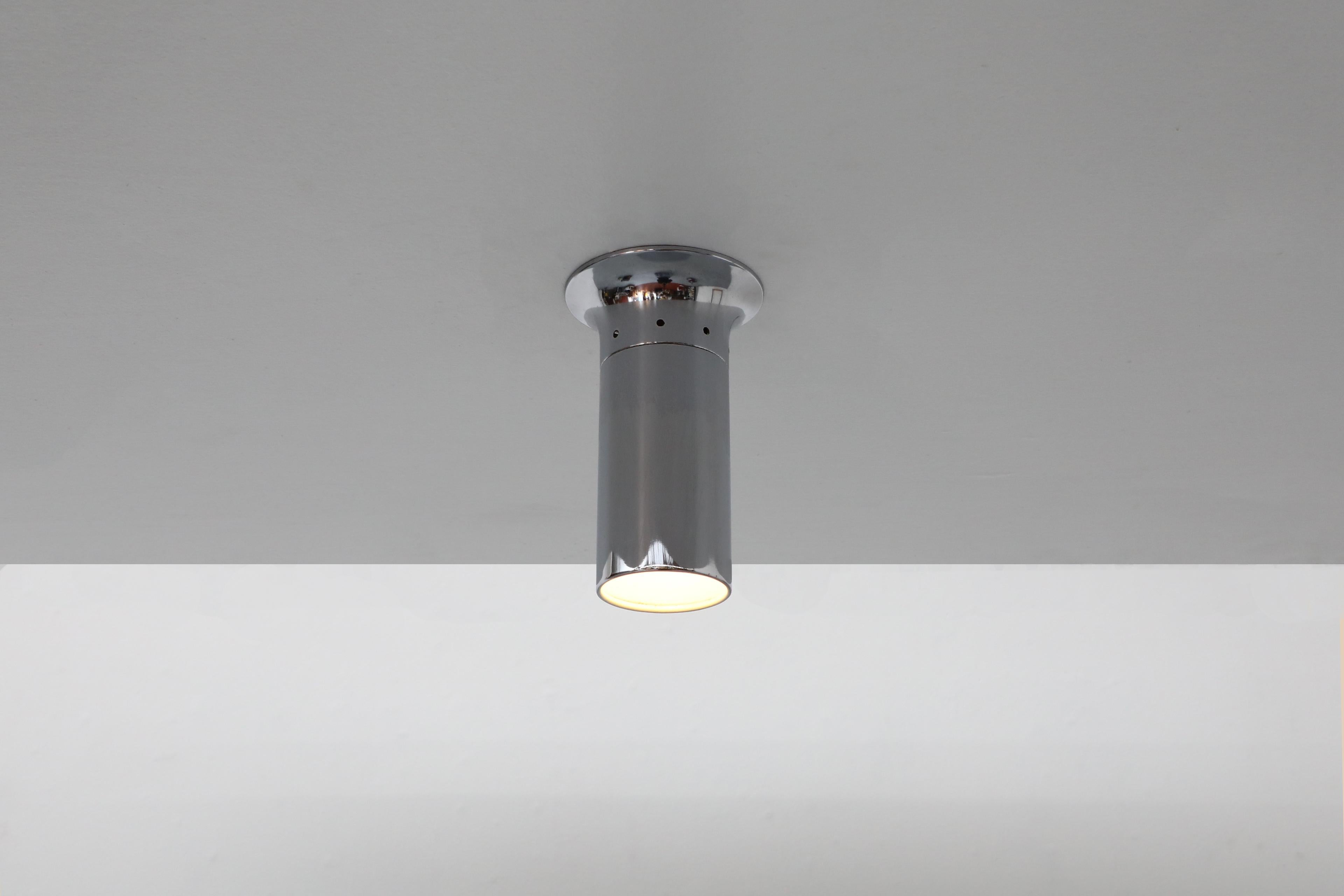 Mid-Century polished chrome flush mount ceiling sconce with tulip-like base. This sleek and slender Raak style tubular light is ideal for a closet or hallway ceiling. An attractive directional light source in original condition with some visible
