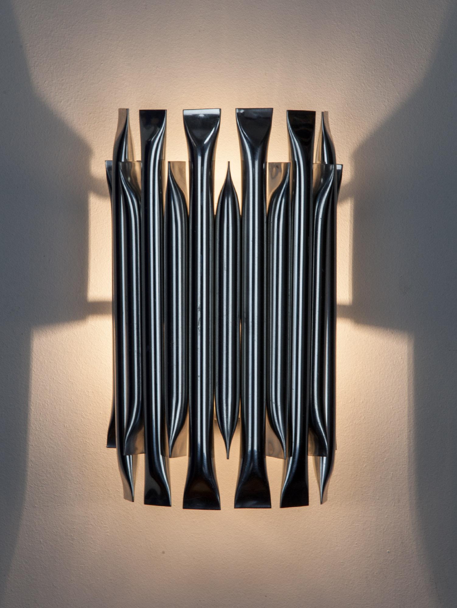 Striking wall light by RAAK with a series of aluminium tubes, in alternating lengths, arranged in an arch. The Brutalist inspired design creates an impressive graphic with either the light on or off. Made in the Netherlands in the 1970s.

Great