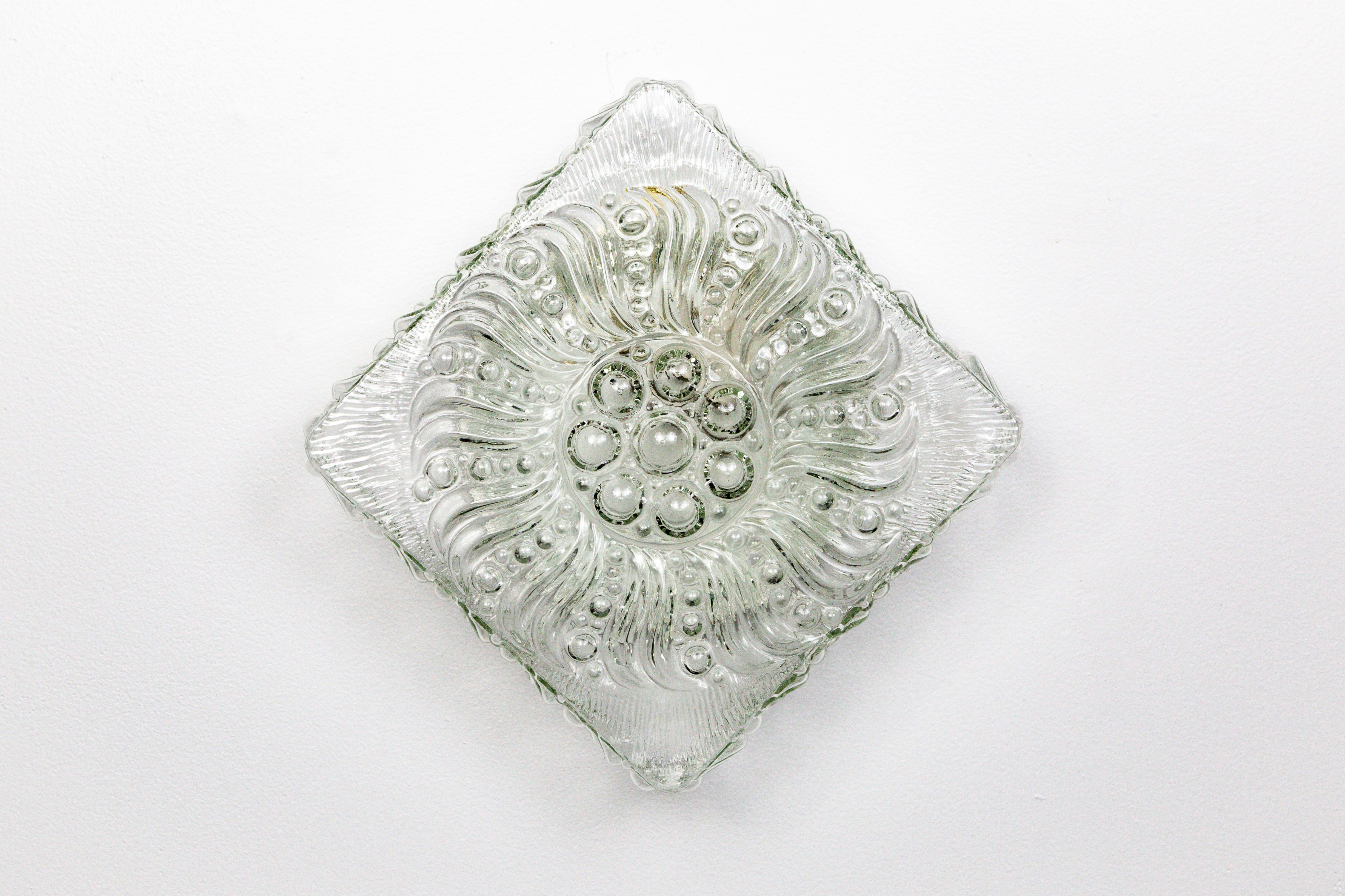 Lampe en verre moulé brillant aux formes complexes, en forme de bulles et de tourbillons, datant des années 1960. Il est très esthétique sur un mur, qu'il soit orienté en carré ou en losange, et constitue un luminaire de plafond tout aussi élégant.