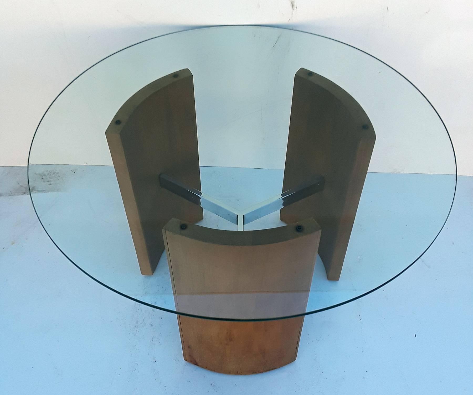 Three curved wood stands connected by chrome stretchers make up this Vladimir Kagan Radius table. Many possible uses from an end table to a plant stand. Glass 30 inch diameter base without glass about 20 inch diameter.
