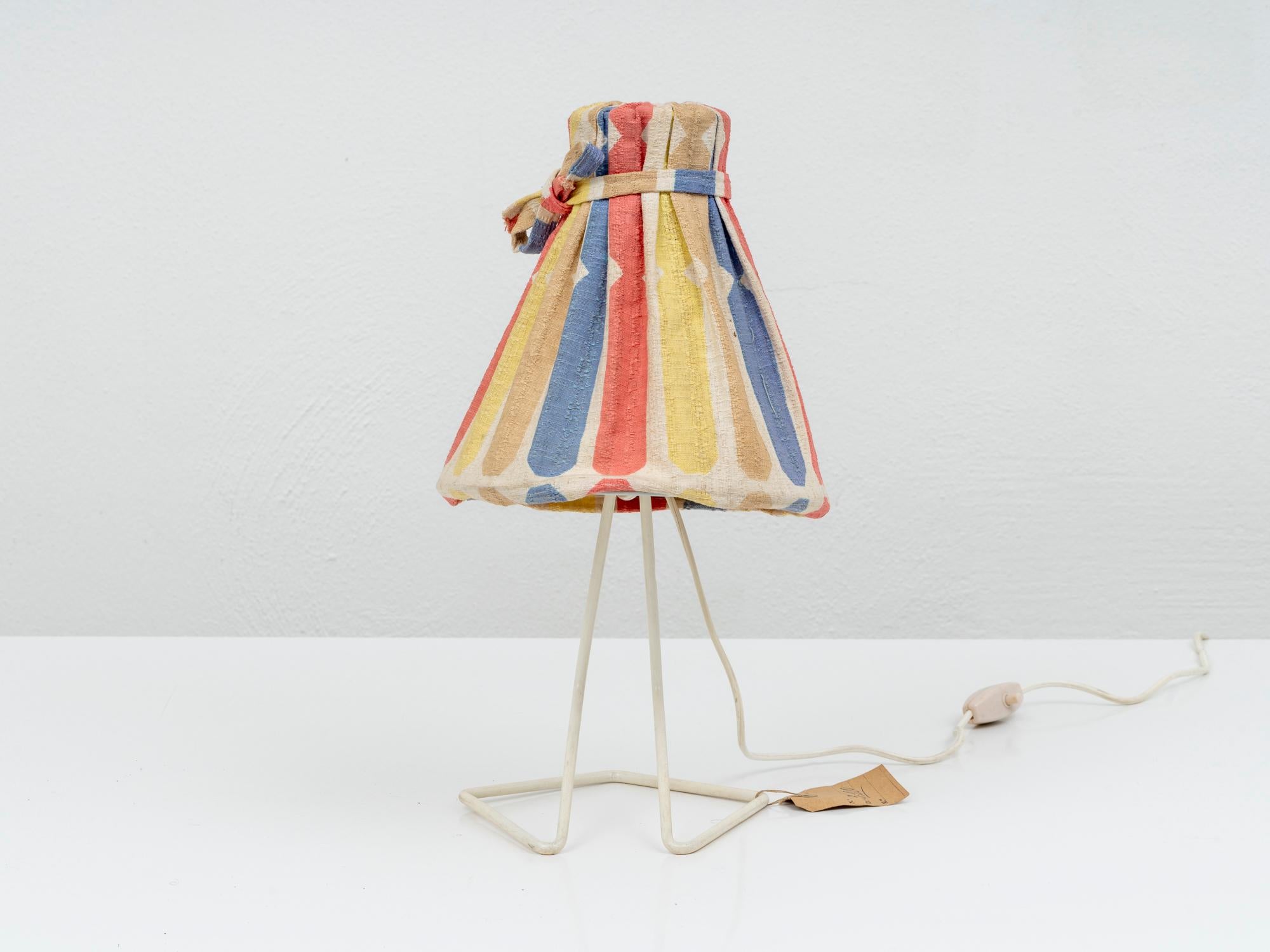 This very rare lamp was designed and manufactured in early 1960s by Stilnovo, one of the most prominent mid-century Italian lighting company. It is made of a iron structure varnished in white, with a colorful printed fabric shade. Thanks to a joint,