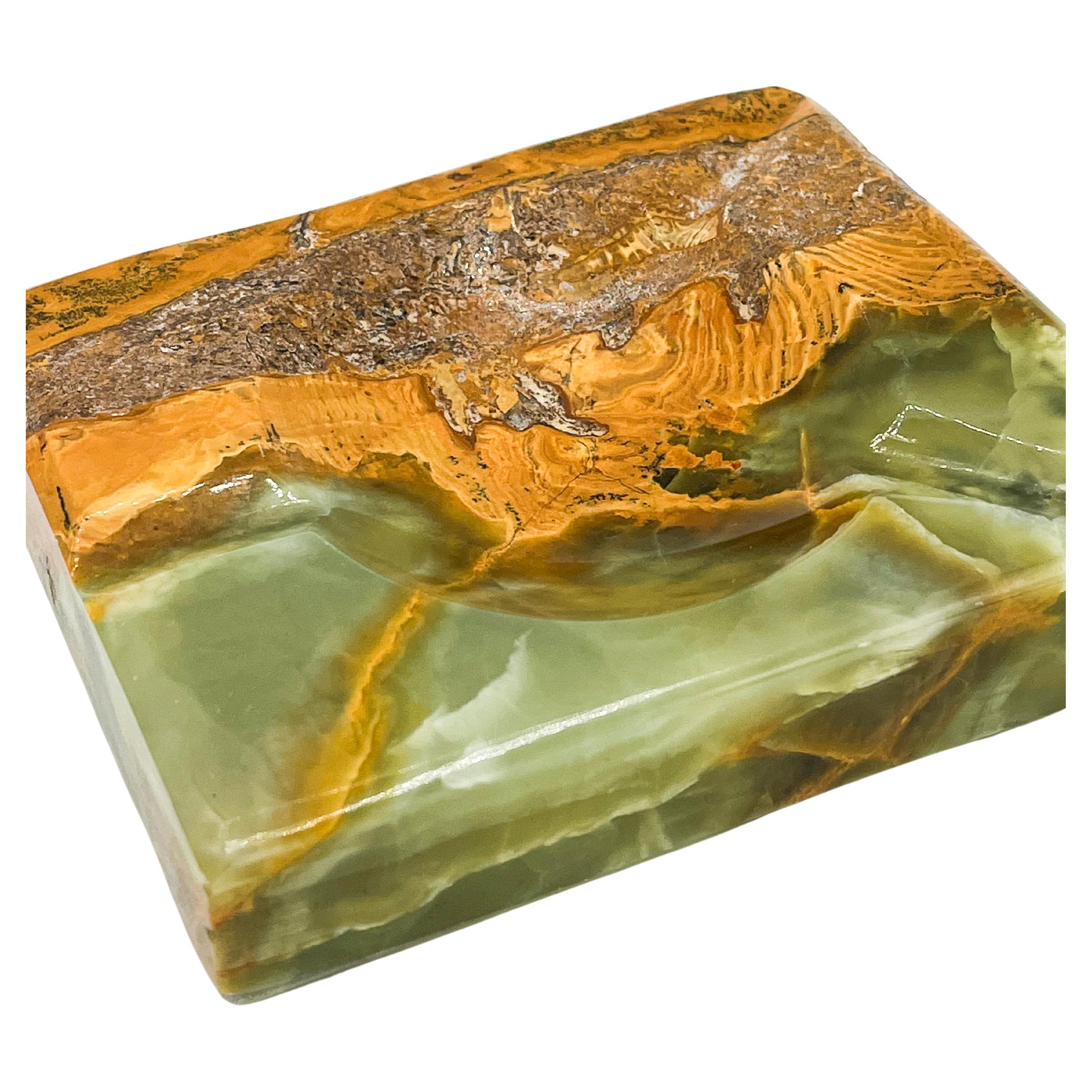 This stunning mid-century onyx catchall ashtray, handcrafted in the 1970s, features a beautiful blend of green and brown hues, creating a natural and elegant aesthetic. The unique design highlights the natural veining of the onyx, giving it an