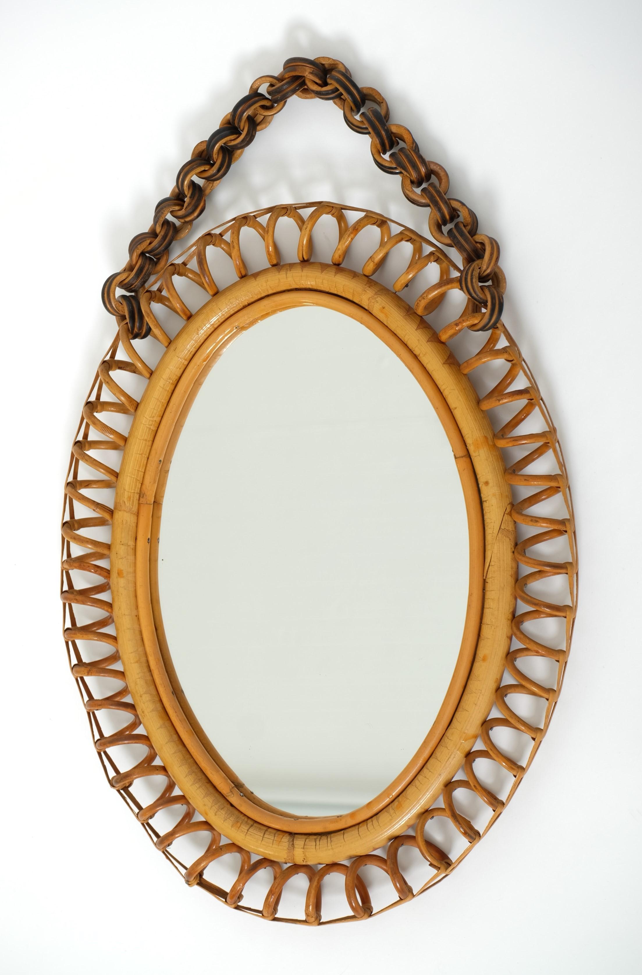 Highly decorative oval Mid-Century Modern wall mirror with a wavy rattan frame, Italy, 1950s.

Beautiful Italian Mid-Century design, in the style of Franco Albini. The mirror frame is finished with a looped weave all the way around. This oval mirror