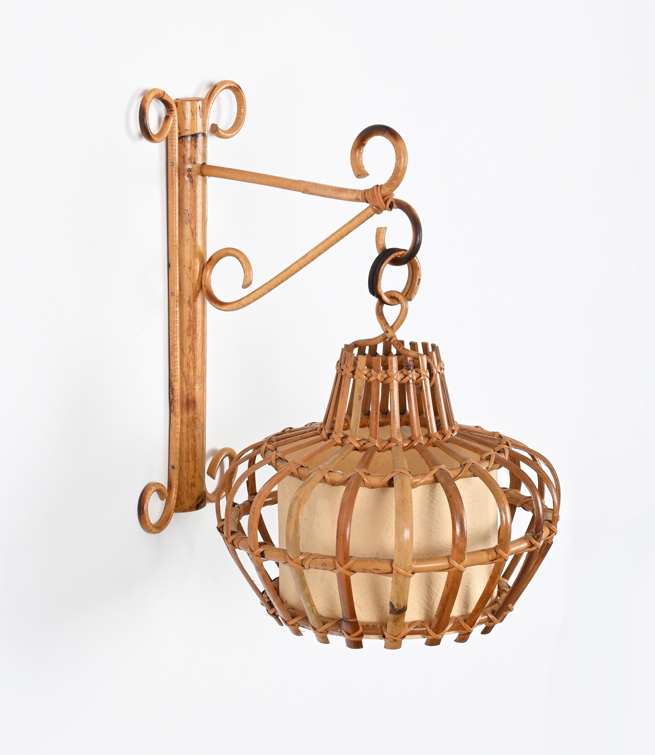 Splendida lampada da parete in stile Costa Azzurra realizzata in rattan curvo, vimini intrecciato a mano e canna con paralume in pergamena. Questa incantevole applique è stata realizzata in Francia negli anni '60 ed è attribuita a Louis