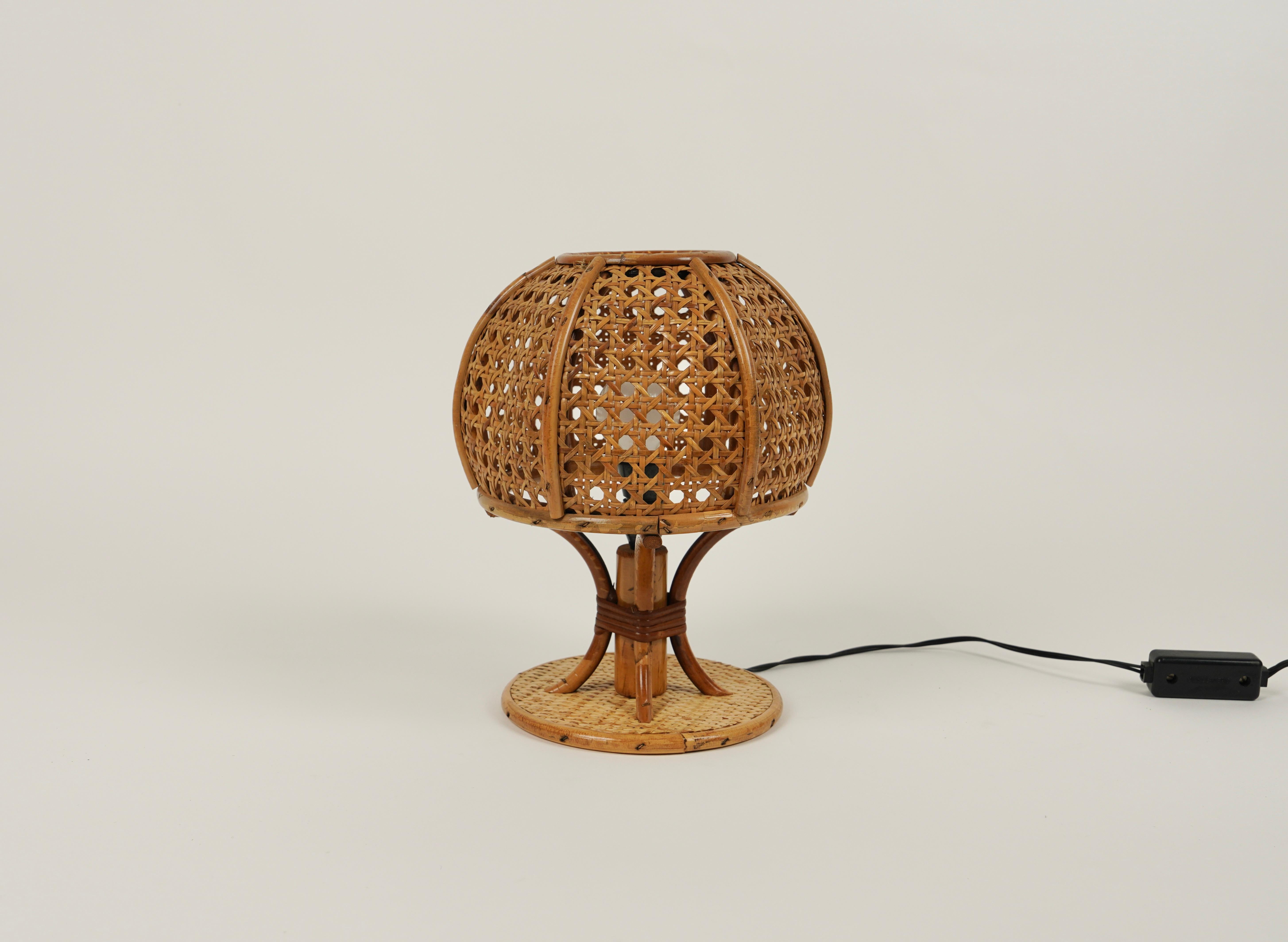 Beautiful table lamp in rattan and wicker in the style of Louis Sognot. 

Made in Italy in the 1970s. 

Louis Sognot was a French designer best known for his elegant furniture made from a combination of rattan and wood. Sognot was influenced by