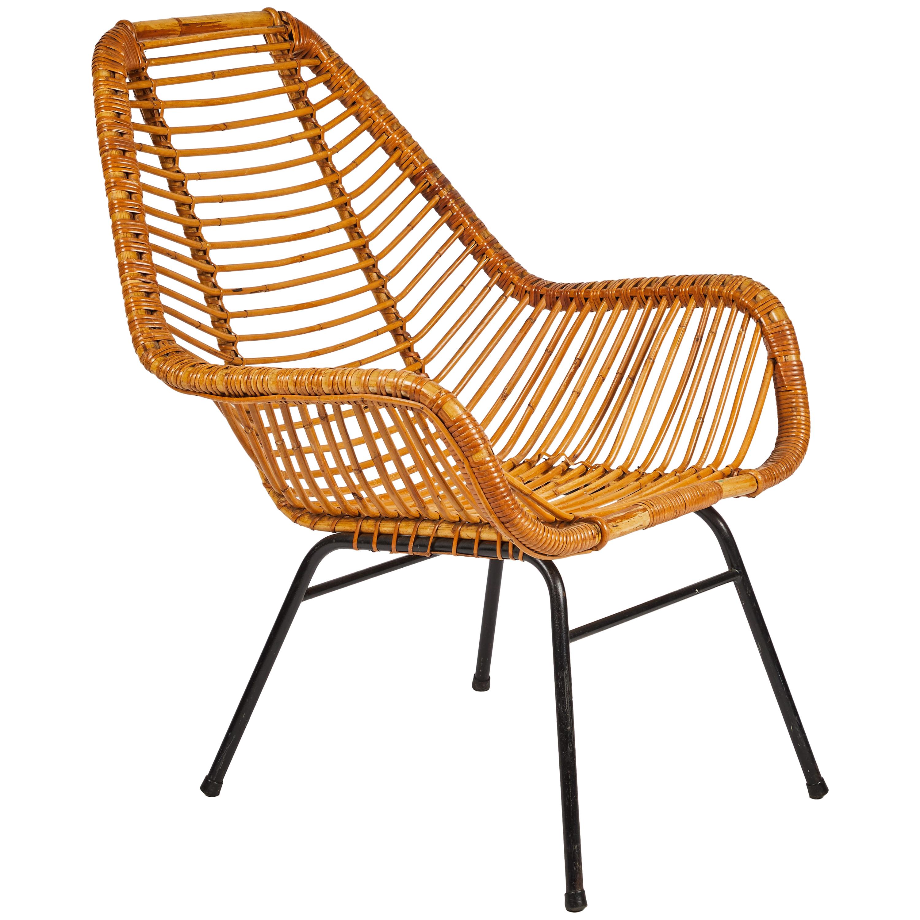 French mid-century rattan armchair with metal base. Warm and beachy, or sleek and modern, this versatile piece invites you to relax. The simple repetition of lines and soft curves gives this classic chair its sex appeal. 

France, circa