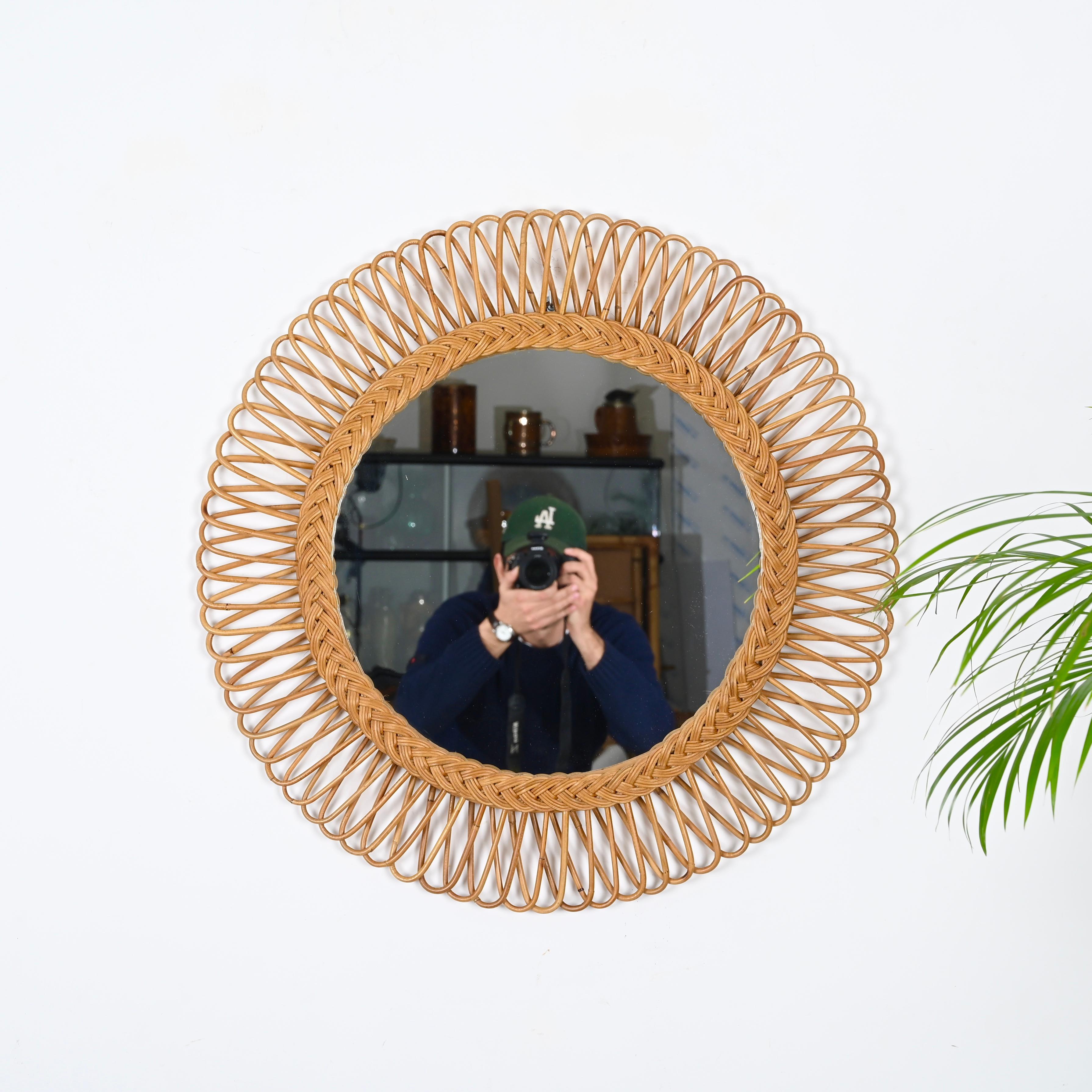 Marvelous mid-century French Riviera style round mirror in Rattan and Bamboo. This beautiful piece was produced in in Italy during the 1970s and is attributed to the mastery of Franco Albini. 

This stunning mirror has a double frame, decorated by