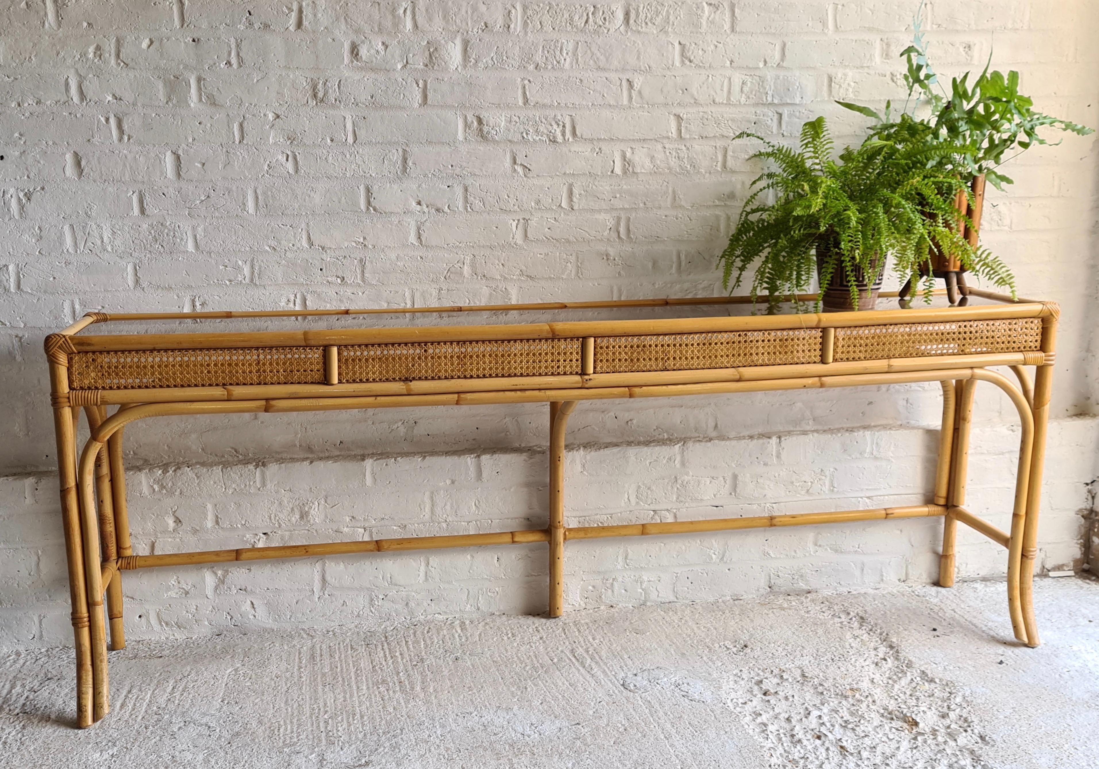 Midcentury rattan and glass top console table, Italian, 1970s

2 meter long midcentury rattan and glass top console table, Italian, 1970s

This extra long rattan console table, with 5mm smoked glass top, and cane weave matting
panels below, is