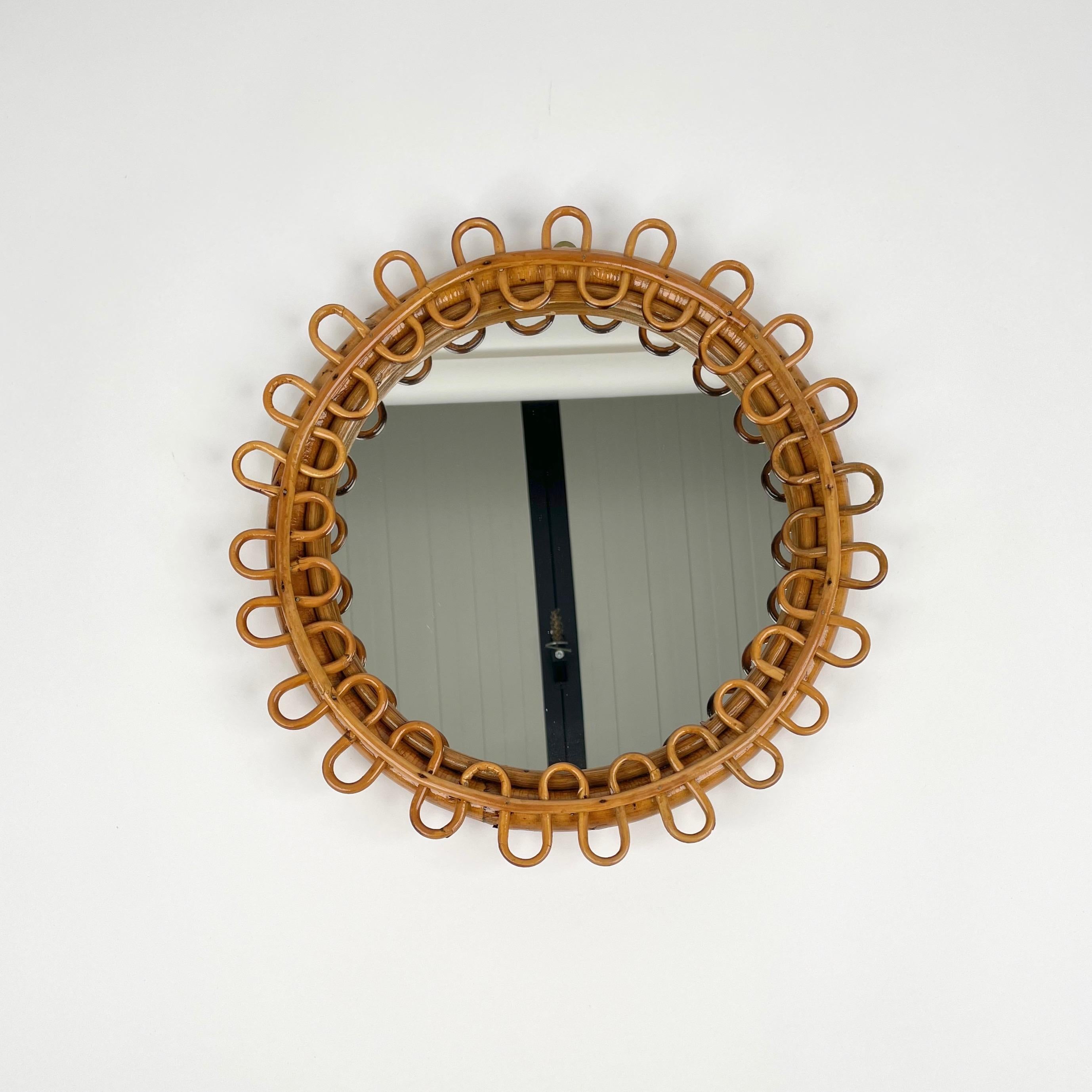 Beautiful little round wall mirror framed by bamboo and rattan. 

Made in Italy in the 1960s.