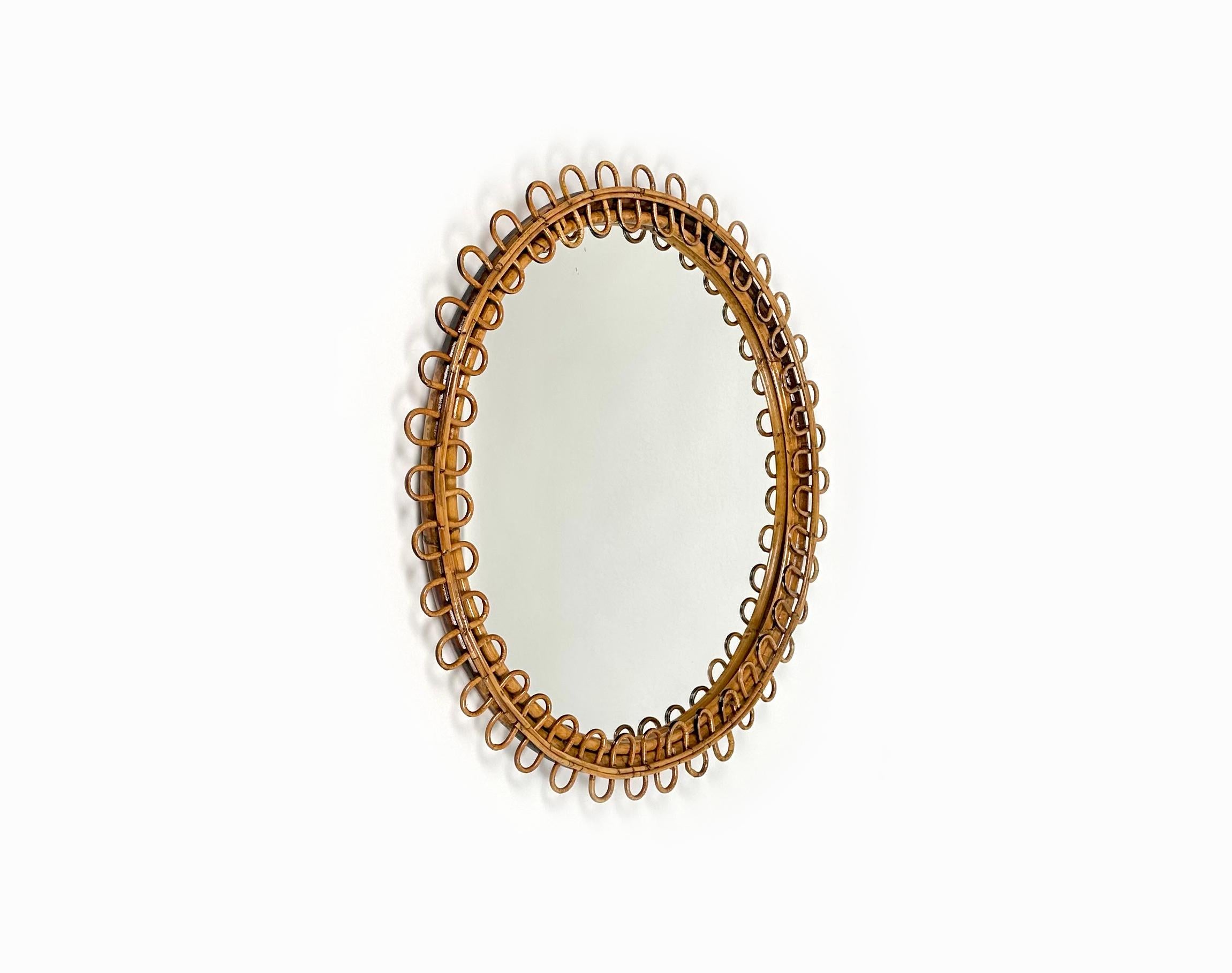 Midcentury beautiful round wall mirror framed by bamboo and rattan in the style of Franco Albini. 

A highly decorative mirror with undulated rattan frame. 

Made in Italy in the 1960s. 

Bamboo / rattan has been polished by a professional
