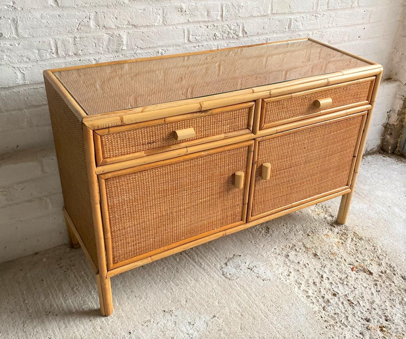 Mid century rattan / bamboo compact sideboard, Italy, 1970s

Mid century rattan / bamboo compact sideboard, wooden structure with rattan and cane detail, covered in close weave French matting, with cane handles. Two drawers above a two door
