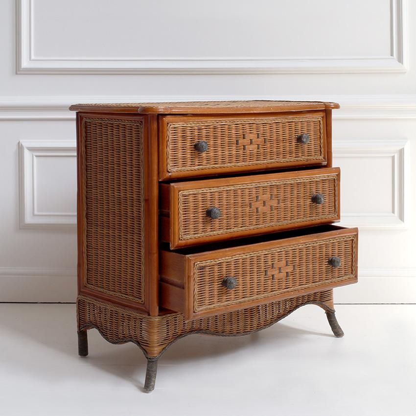 A charming Mid-Century Modern chest of drawers fully constructed of richly woven rattan, featuring three generously sized drawers accented with a distinctive diamond-patterned weave. The subtle curves of the skirt and tapered legs introduce a
