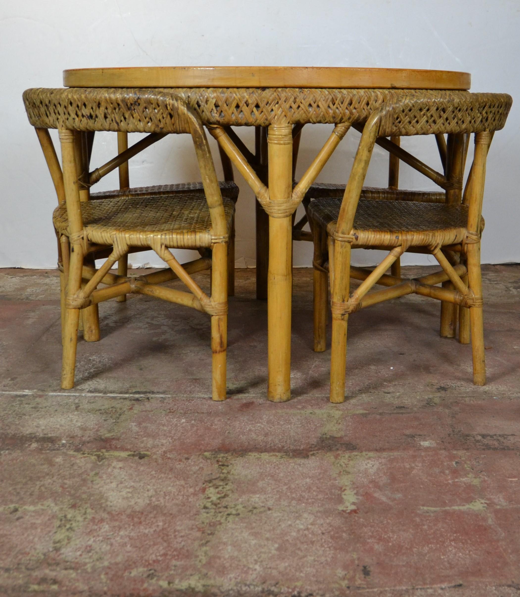 The set compromised of four three-legged, woven seat, woven back fit the shape of the table giving it a clean look. The top of the table is marquetry solid wood. Measures: Table 42