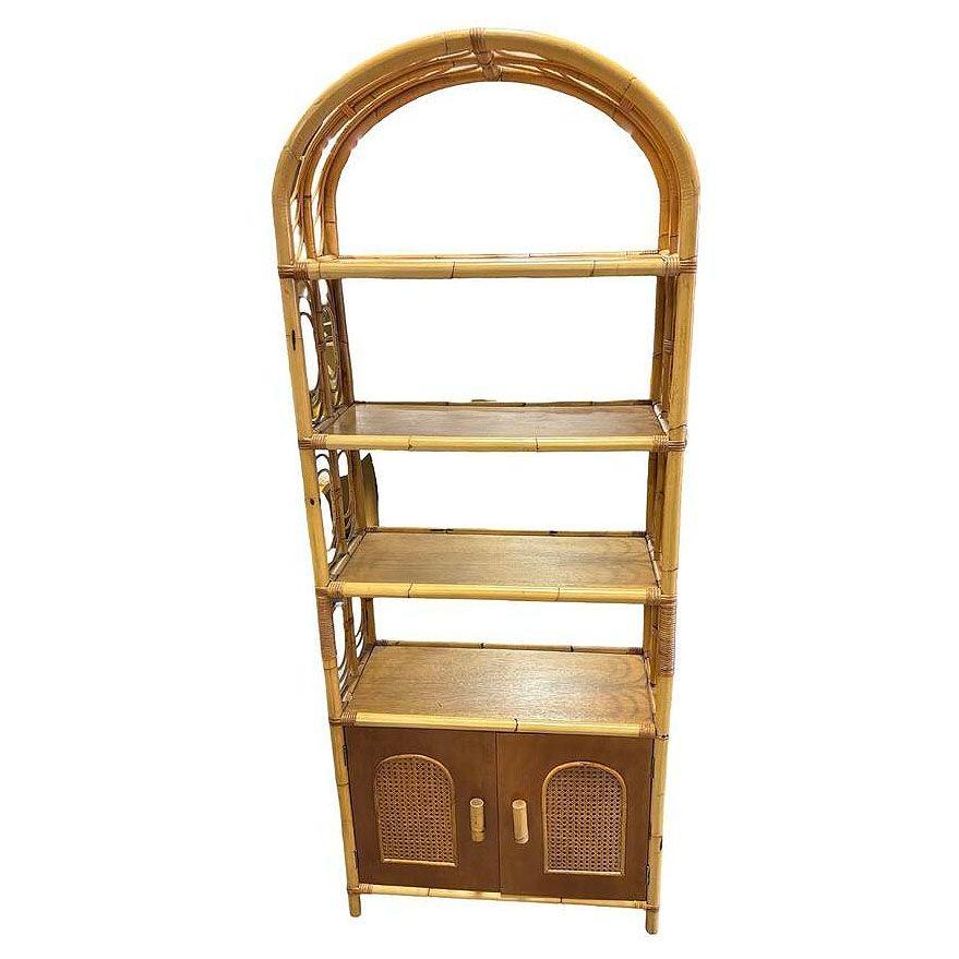 This beautifully restored Paul Frankl-inspired high-style rattan étagère showcasing four open shelves and a bottom two-door cabinet with two interior shelves for added storage. The cabinet has large arched sides with finely woven wicker accents