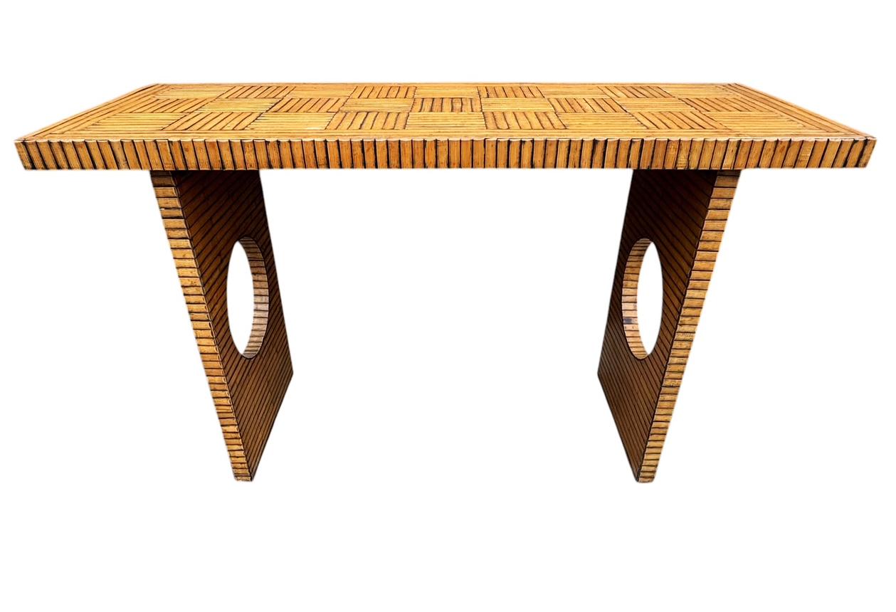 An usual vintage console table from the 1970's. Geometric design in split bamboo clad. In the style of Danny Ho Fong. 