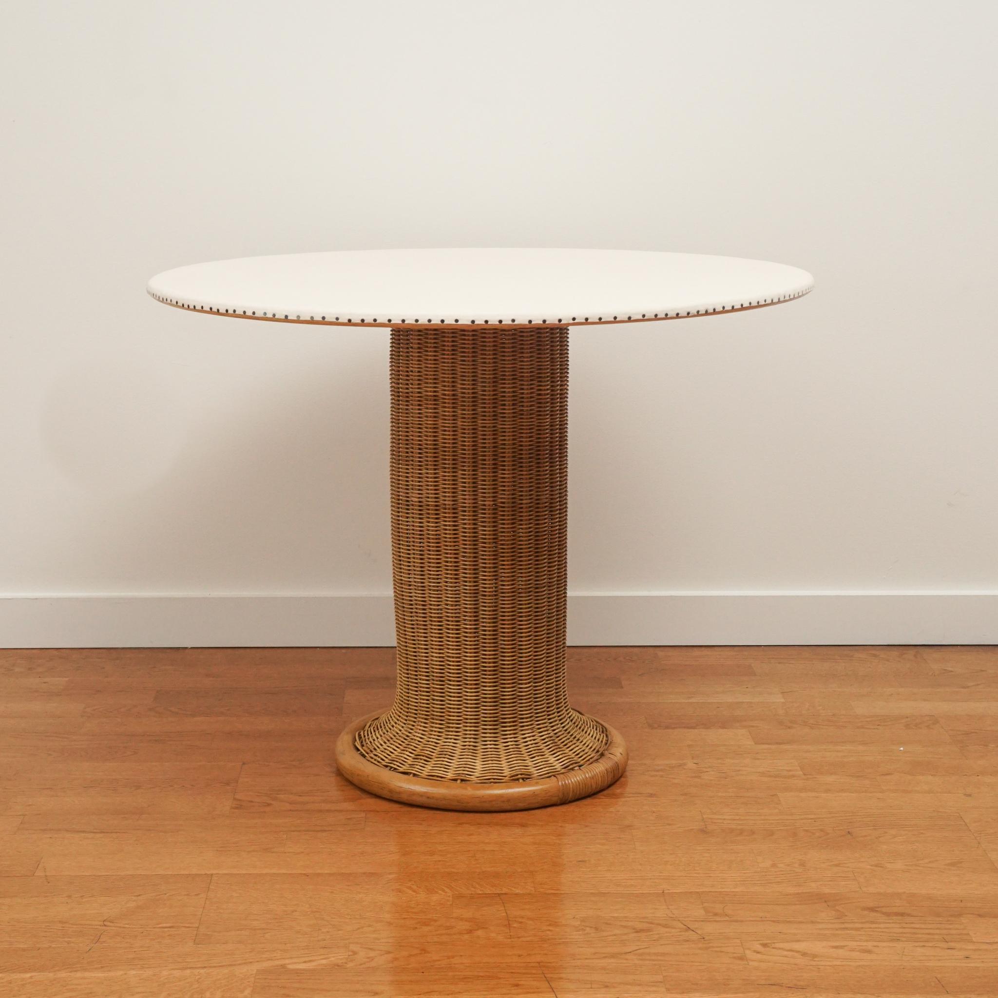 While this Italian rattan breakfast table dates to the 1940s, it is anything but dated.  The woven rattan pedestal base and fabric covered top make it as modern as if it were just made.  The fabric top is detailed with upholstery nails to give it a