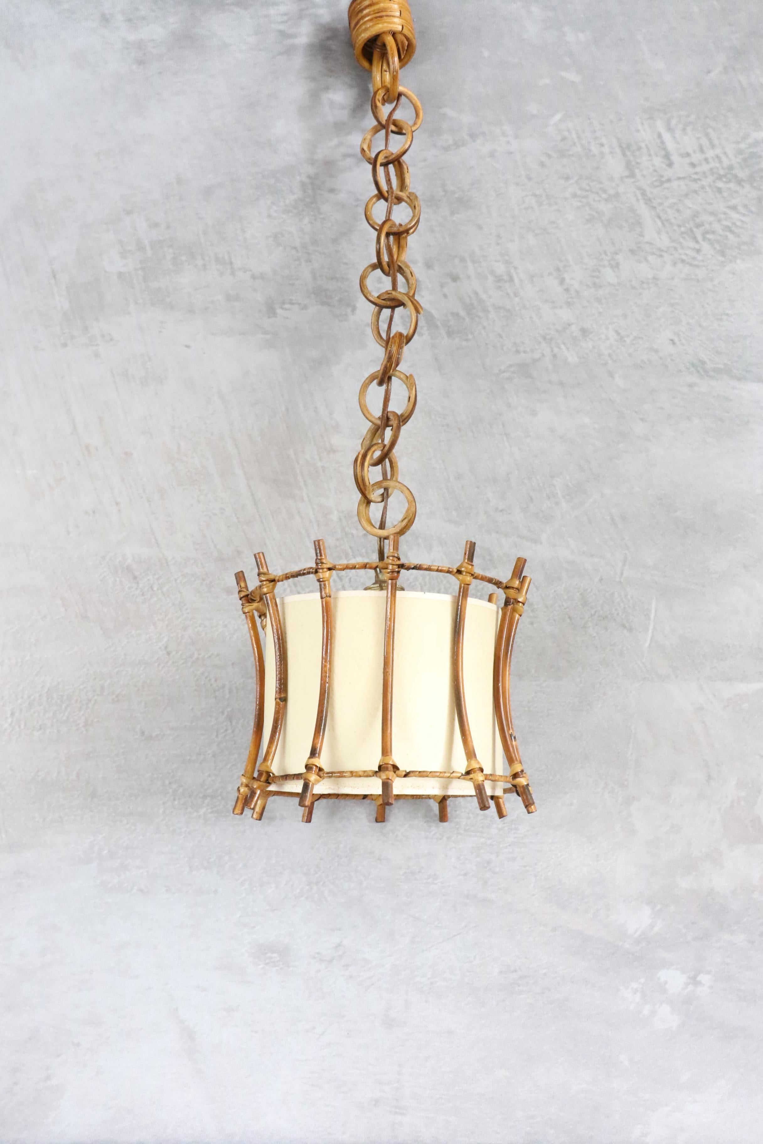 Rattan Pendant Hanging Light, Spain, 1960s

This lantern features a beautiful design with a spherical rattan structure. 
It has a paper shade inside to diffuse a soft, warm light. It is suspended from a rattan link chain. The length of the chain can
