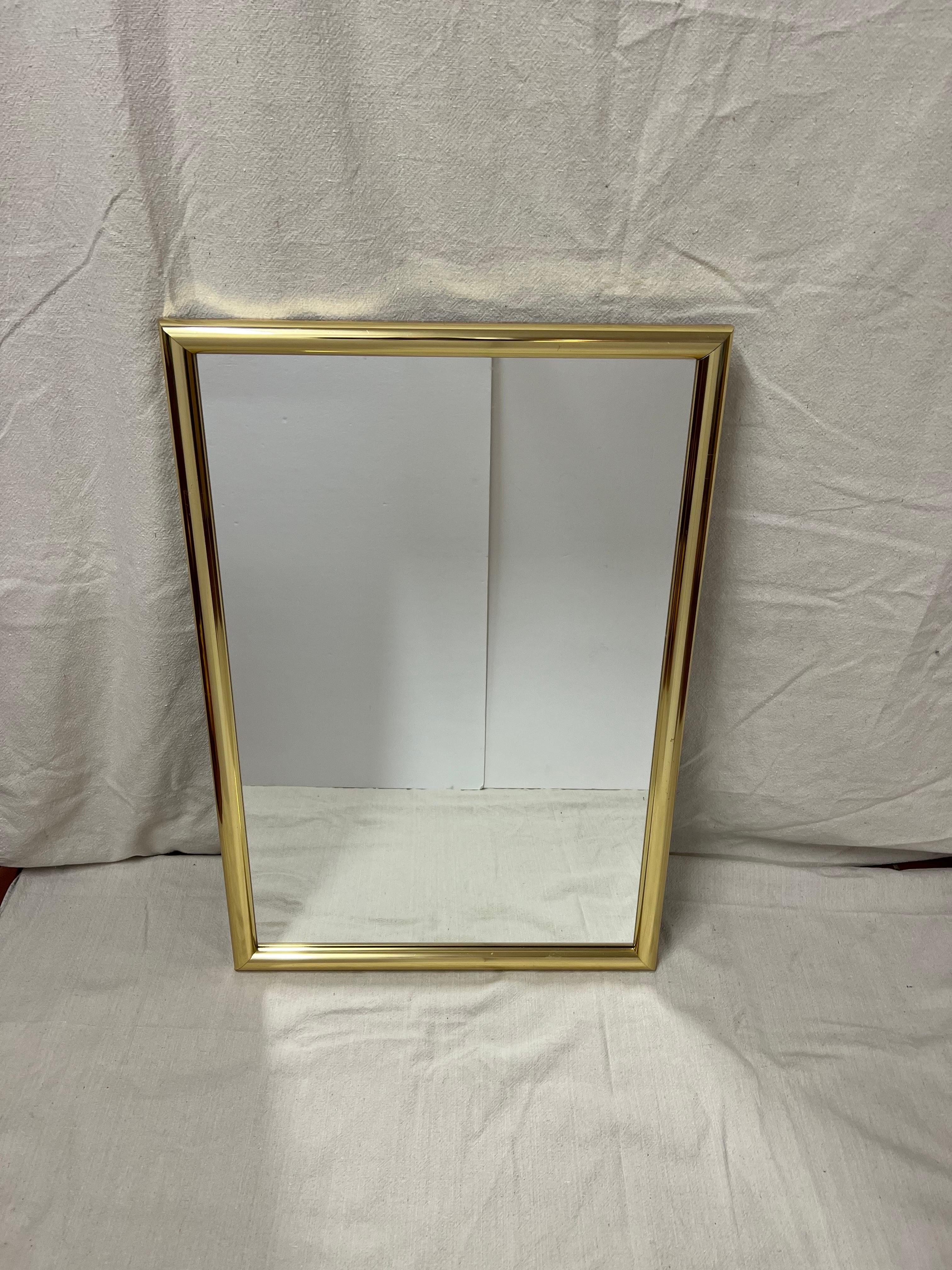 Mid-century minimalist rectangular brass mirror. Perfect for an entry way or a small powder room. Nice thick frame .