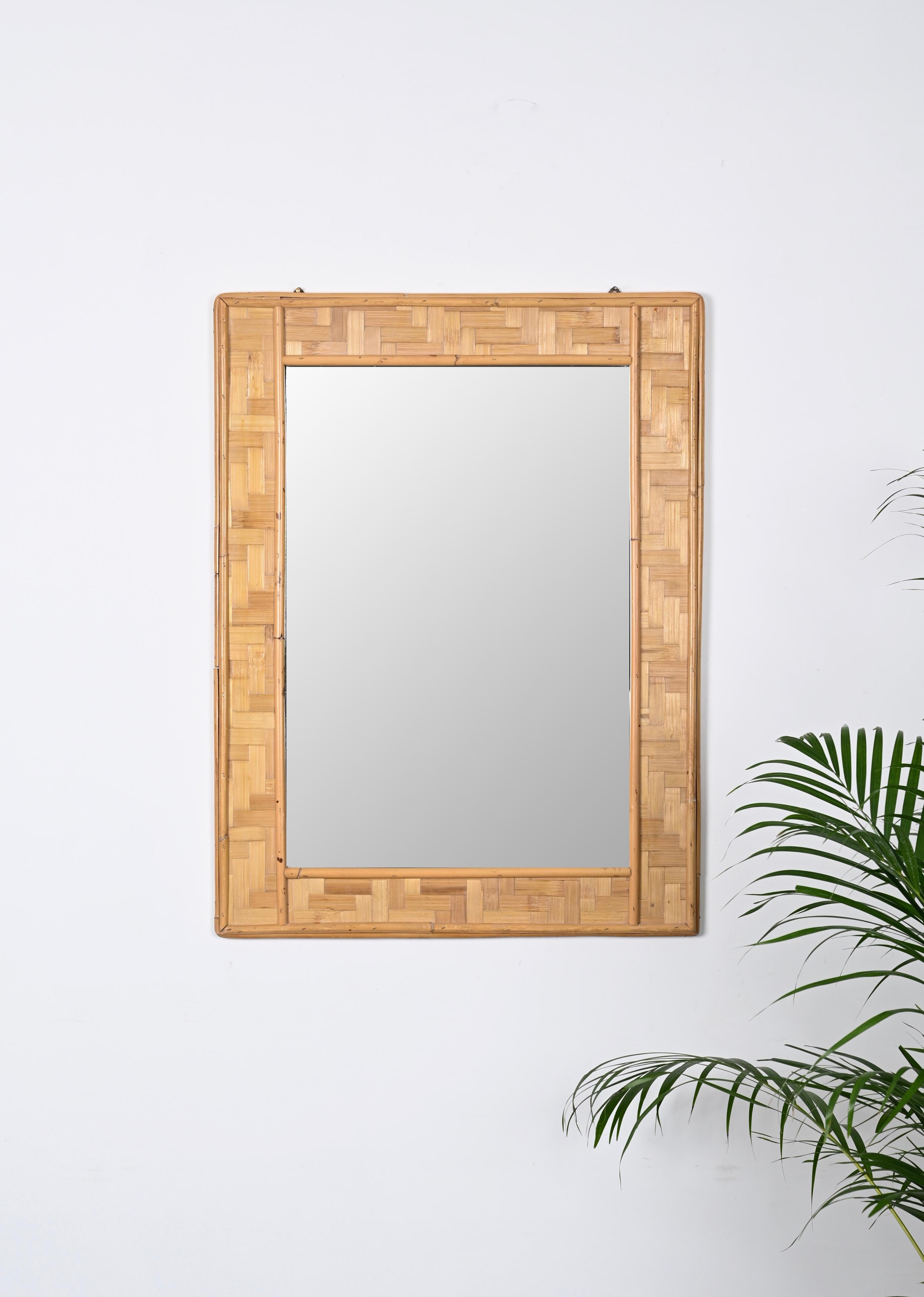 Astonishing midcentury rectangular bamboo and woven rattan mirror. This fantastic piece was designed in Italy during the 1960s.

This mirror is fantastic thanks to its fantastic frame, made of straight lines give by the external and internal