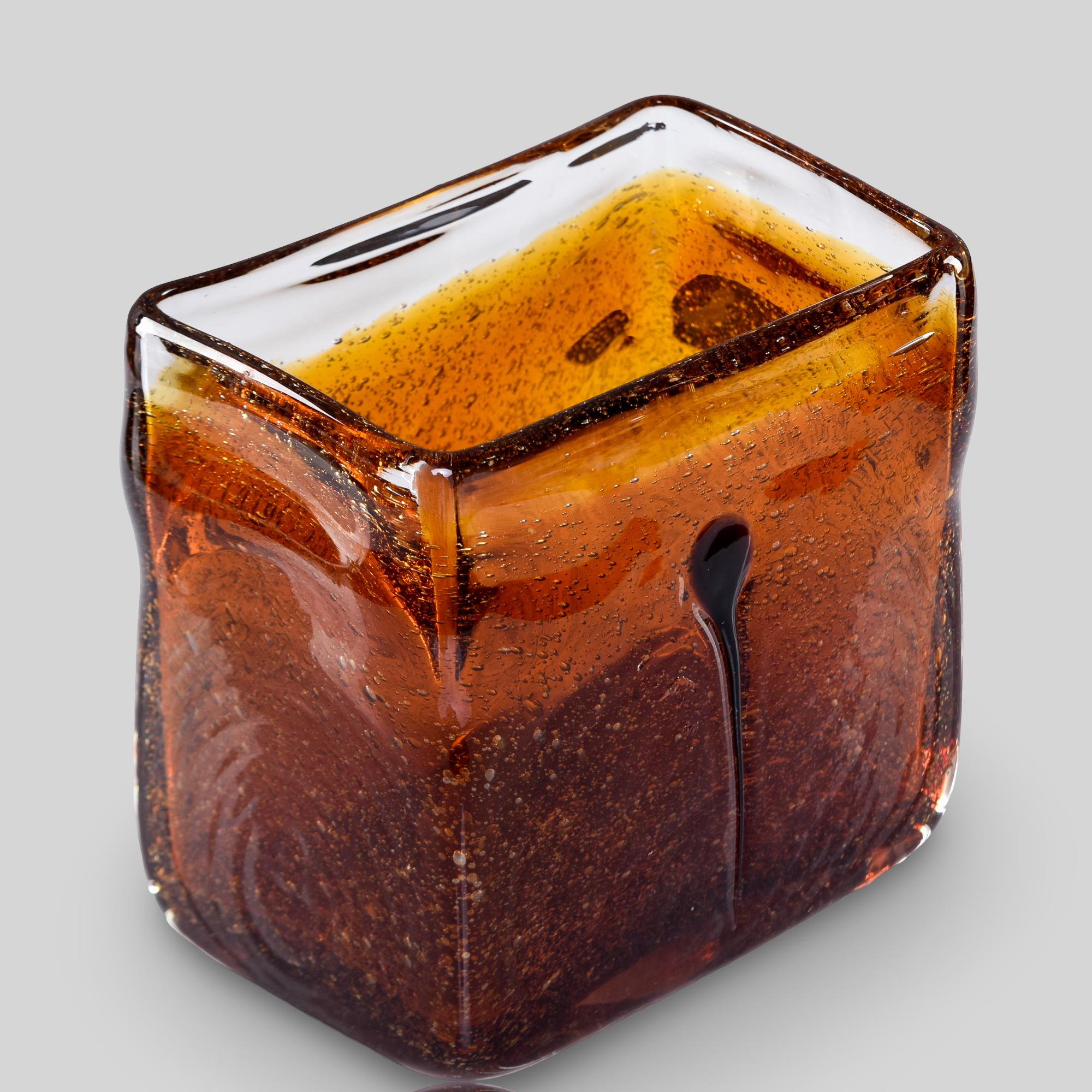 Trovato in Italia, questo vaso rettangolare vintage in vetro di Murano risale agli anni Ottanta. Vetro spesso e trasparente con corpo in vetro ambrato scuro. Tante piccole bollicine e una striscia di colore ambrato scuro. Vetro soffiato a bocca con