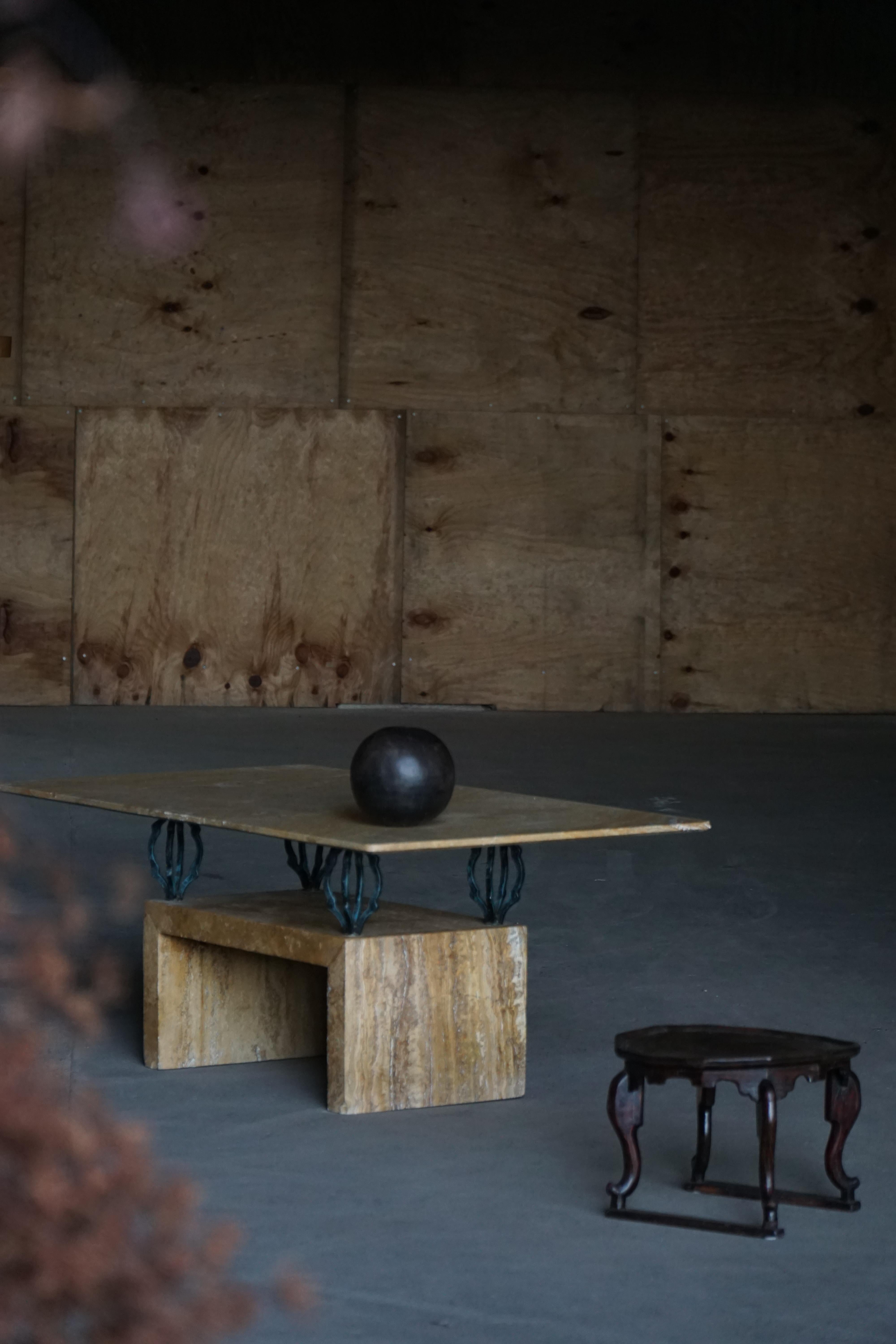 Esta hermosa mesa de centro rectangular, fabricada en Italia en la década de 1970, es un elegante ejemplo de diseño de mediados de siglo con una audaz presencia escultórica. El tablero está fabricado en mármol de tonos cálidos con vetas naturales y