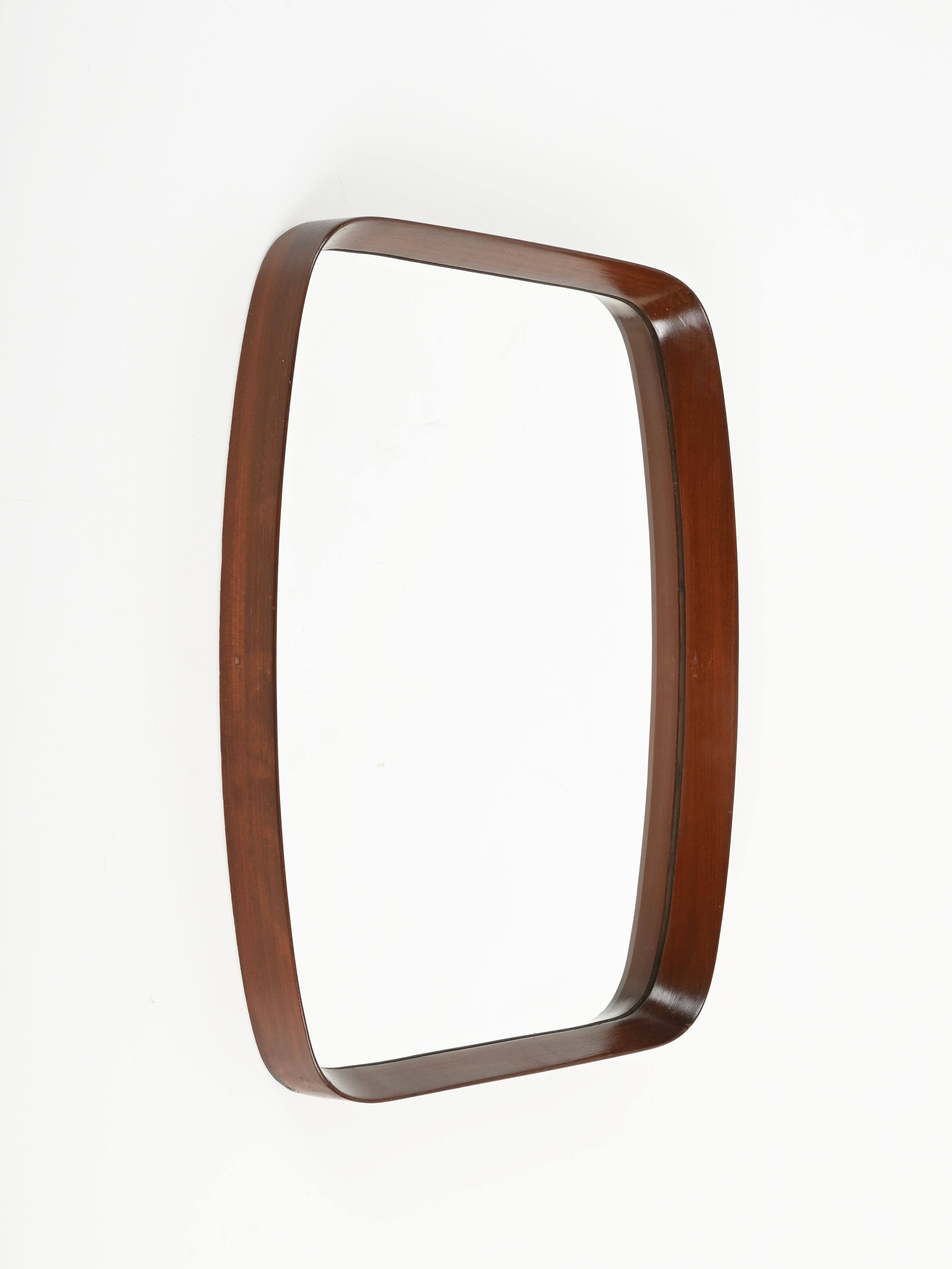 Amazing Mid-Century rectangular mirror in curved teak wood. This fantastic piece was designed by Franco Campo and Carlo Graffi in Italy in the 1960s.

Fully original and in amazing condition. This stylish mirror has a rectangular frame in curved