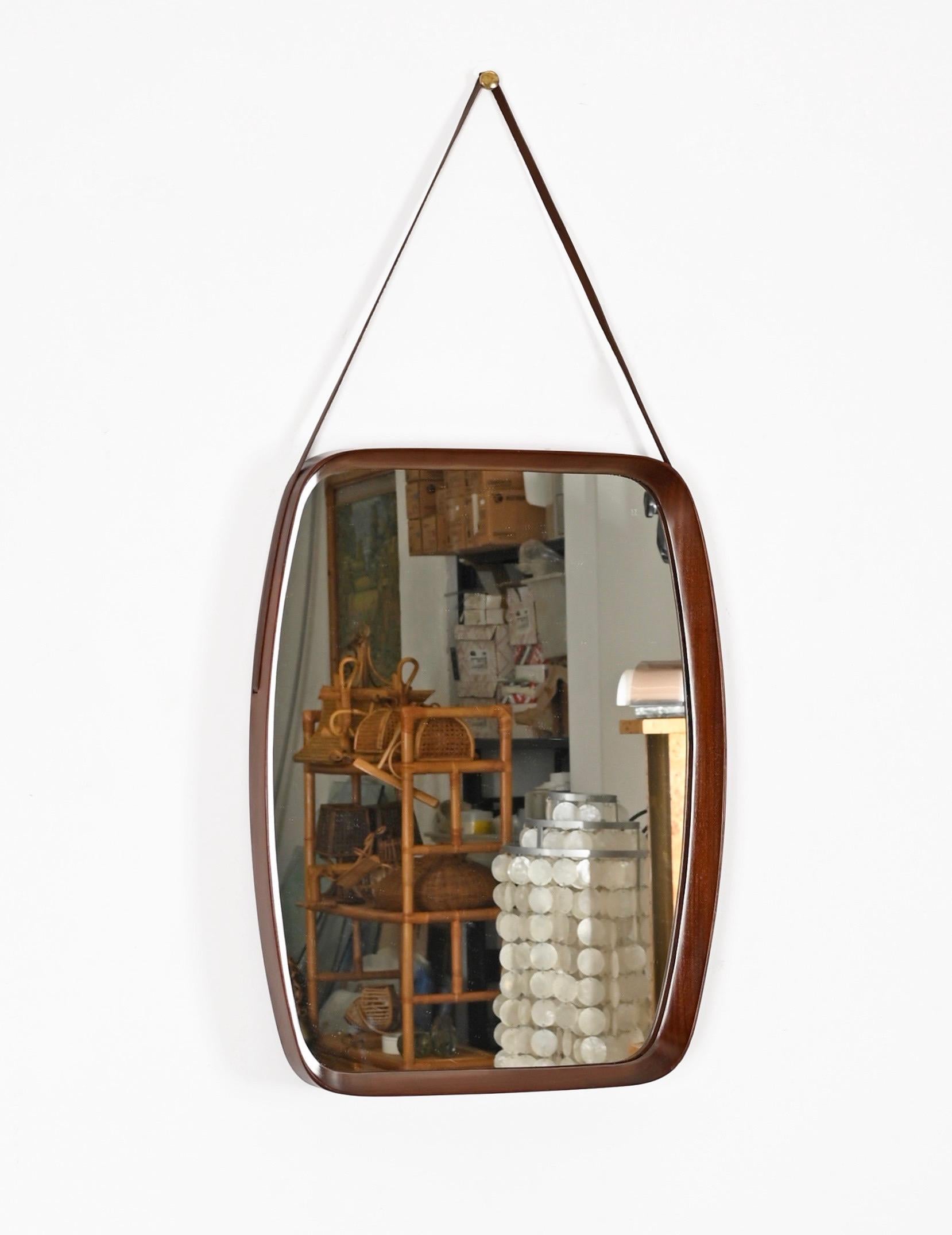 Amazing Mid-Century rectangular mirror in curved teak wood and leather. This fantastic piece was designed by Franco Campo and Carlo Graffi in Italy in the 1960s.

This wonderful piece features a rectangular frame in curved teak wood of outstanding