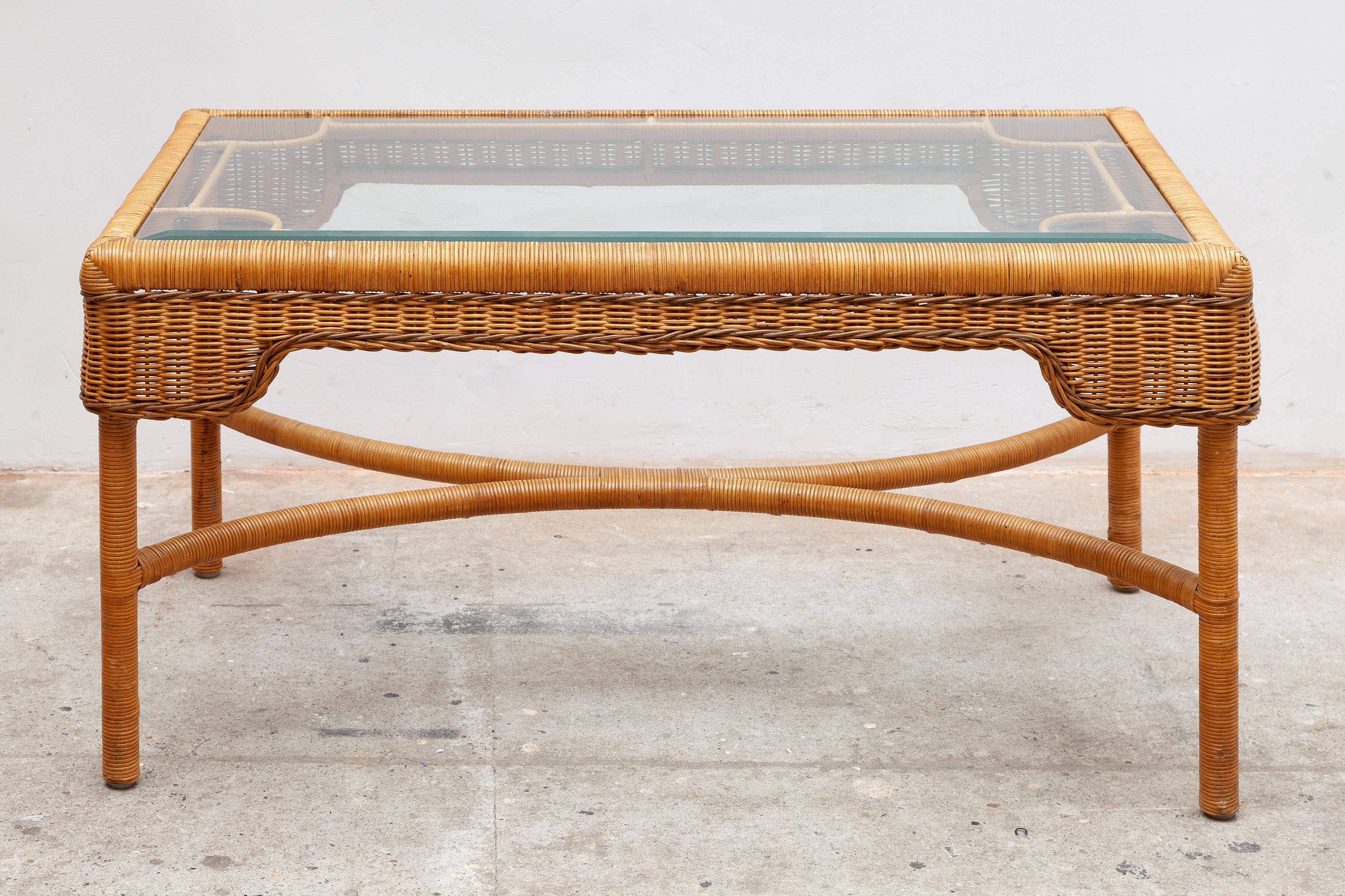 Vintage midcentury rattan coffee table. Elegant lines of the metal frame. The rattan is in excellent condition. Beveled glass top.