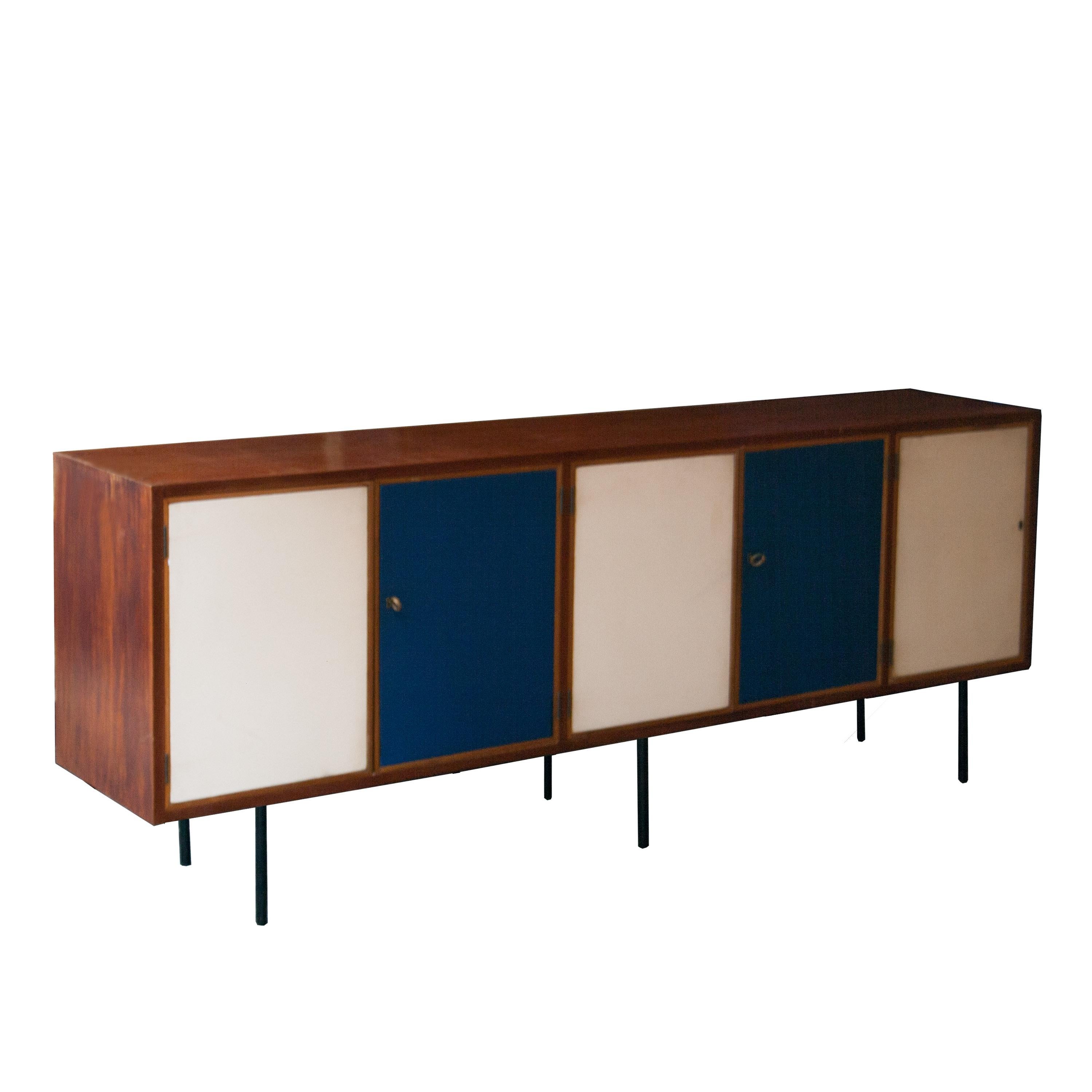 Midcentury sideboard made in mahogany. With five doors on the front, covered in blue and white leather, with wooden frames.
Black lacquered iron straight legs. Brass key and details.
 