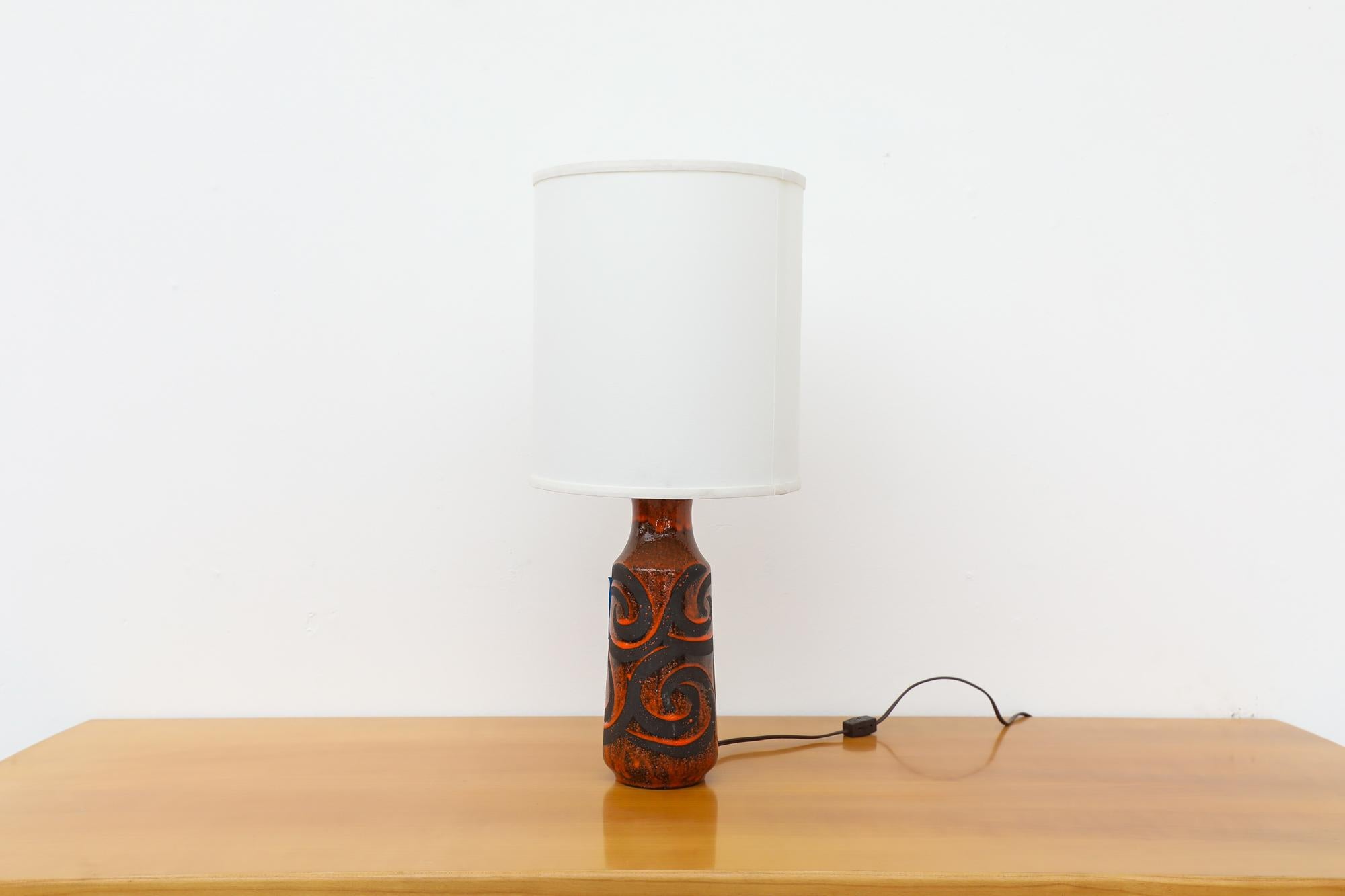 This beautiful Mid-Century table lamp has a ceramic black and red swirl glazed design base and newer white linen shade. The socket uses a standard size bulb. The base and structure are in original condition with visible wear consistent with its age