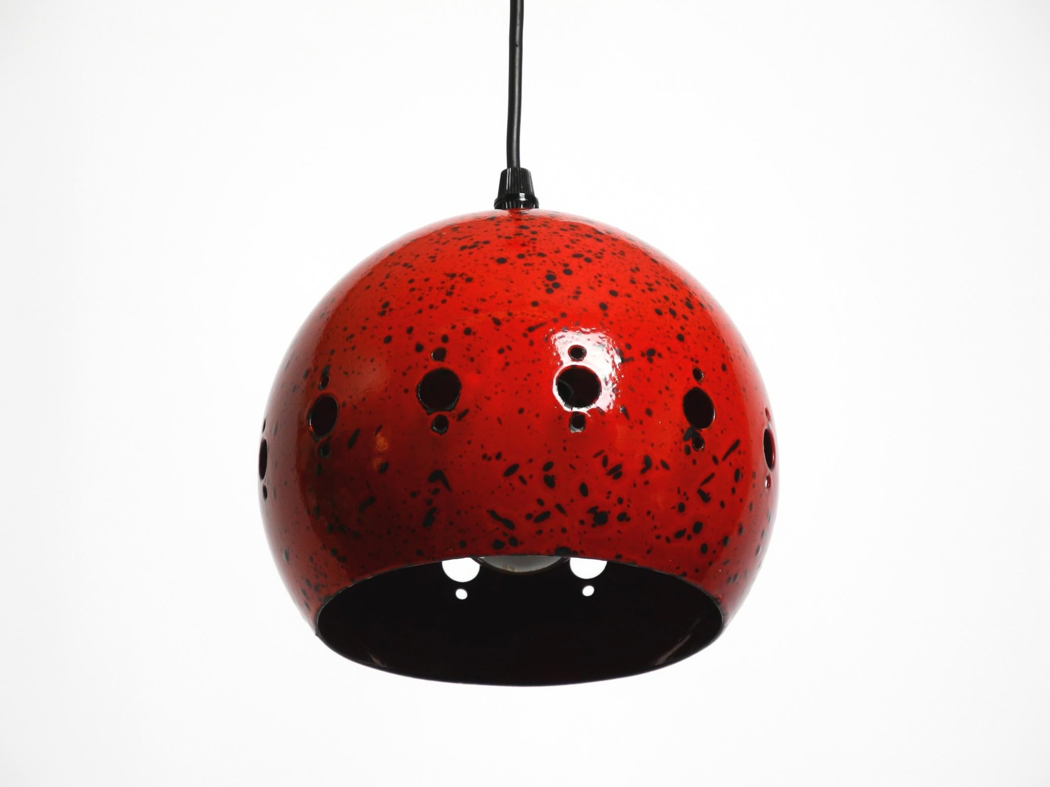 Small beautiful Mid Century Modern red black enameled metal pendant lamp.
Shiny, strong red outside and inside with black dots of different sizes.
The metal canopy is also enamelled on the outside in the same color.
Most likely from Scandinavian