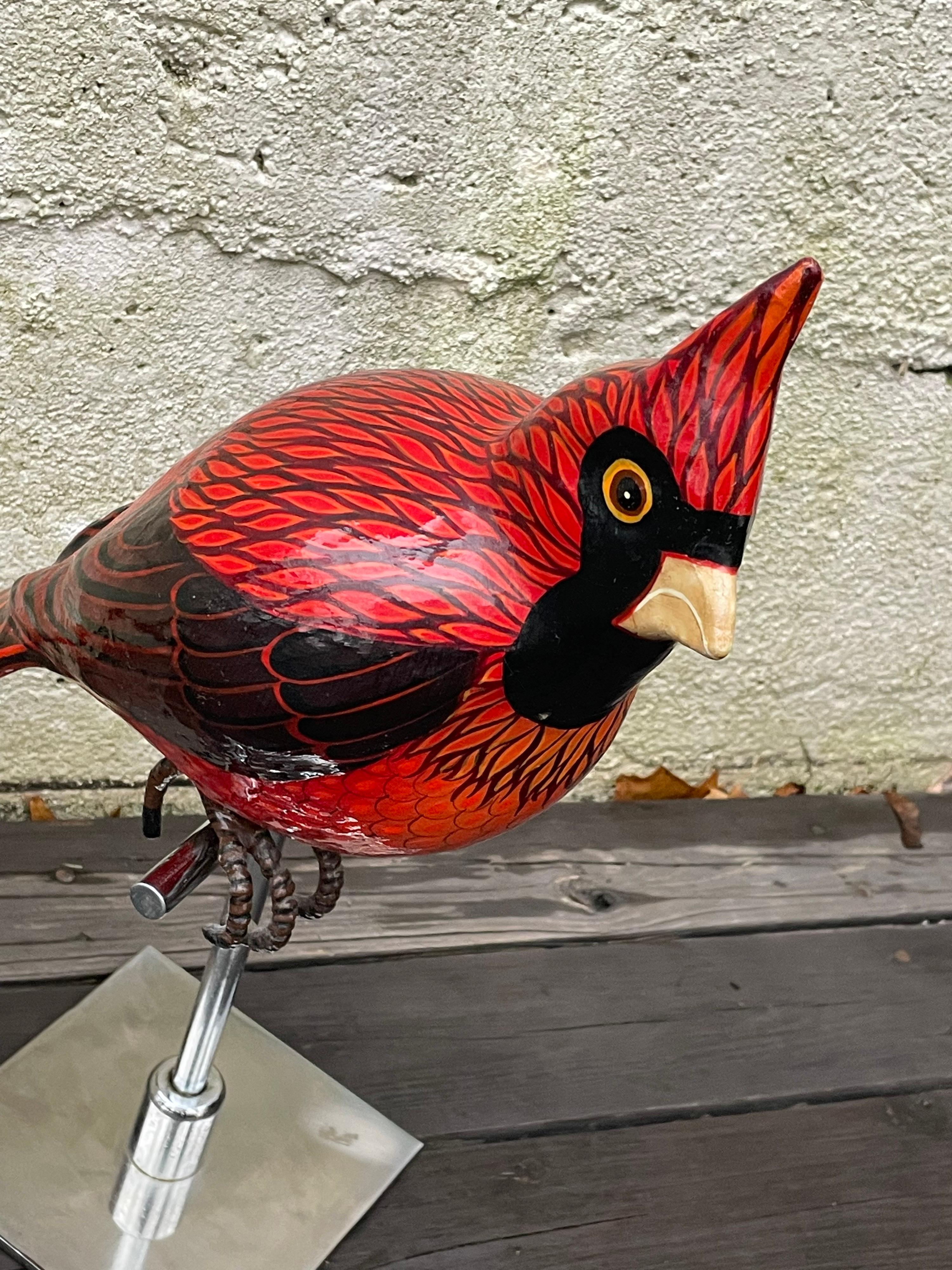 Beautiful perched red cardinal bird sculpture by Mexican artist Sergio Bustamonte, made of paper mache and hand painted, chromed metal Stand. Signed by the artist.