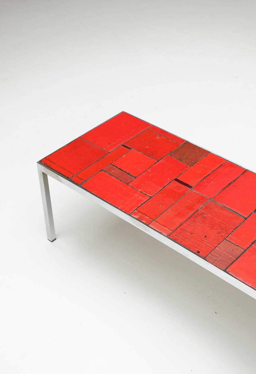 Vermilion red coffee table produced by Amphora, Belgium. Ceramist Rogier Vandeweghe has build up the company together with his wife and ceramic painter Myranna Pyck in the early sixties. They produced ceramic vases , tiles and tables with strong