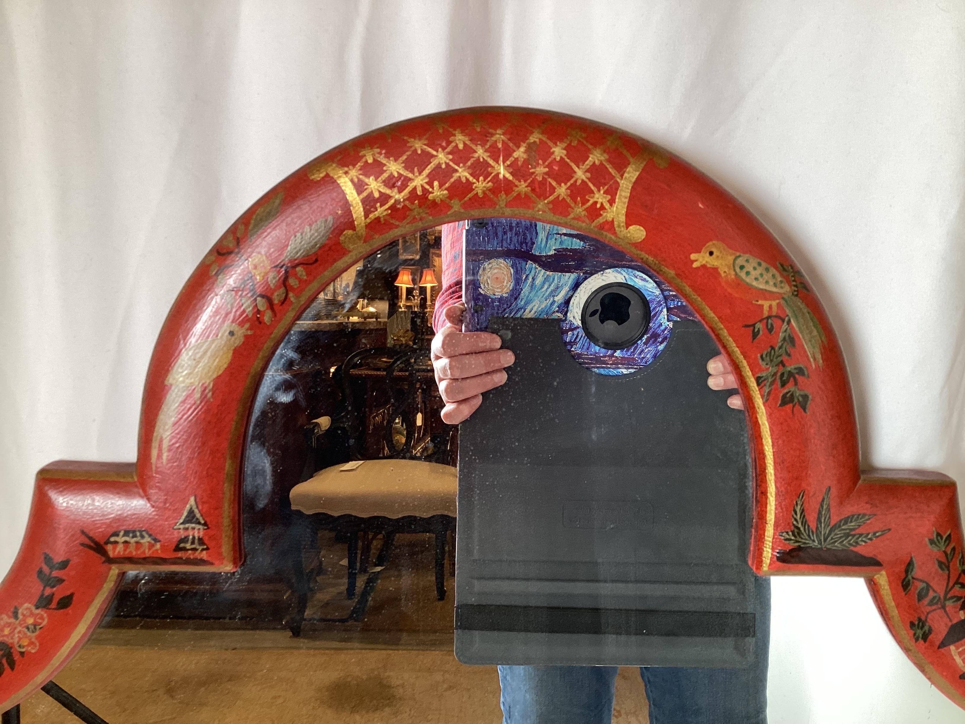 Elegant hand painted chinoiserie mirror by Friedman Brothers. The red background with vibrant Asian inspired decoration on the hard wood frame. 45 inches tall, 22 inches wide.