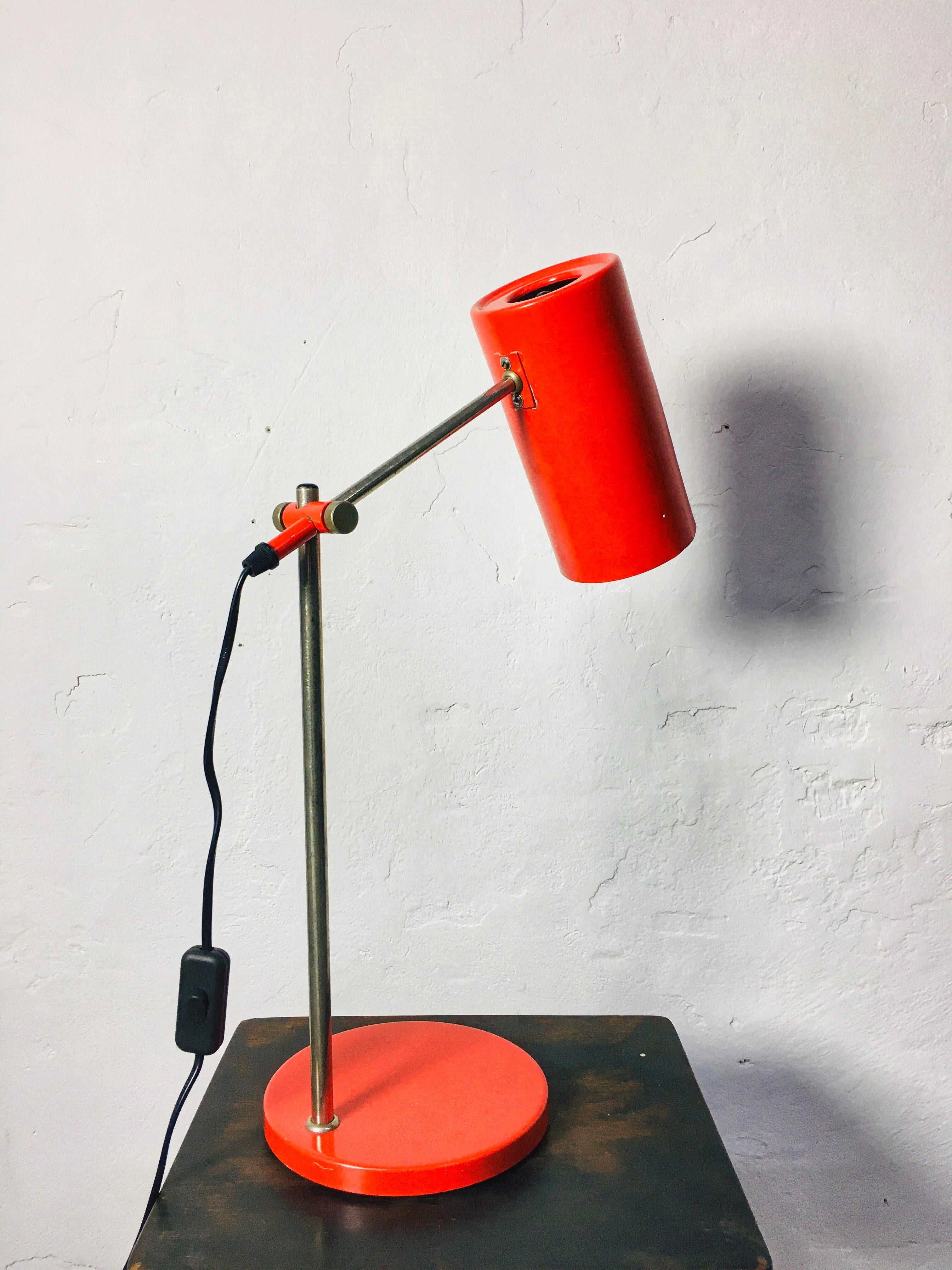 This vintage table lamp, manufactured by Seifert & Tilitz KG in 1960s Germany, features a bright light red color and an industrial style. The lamp's height is adjustable, and it has been electrically refurbished.
 