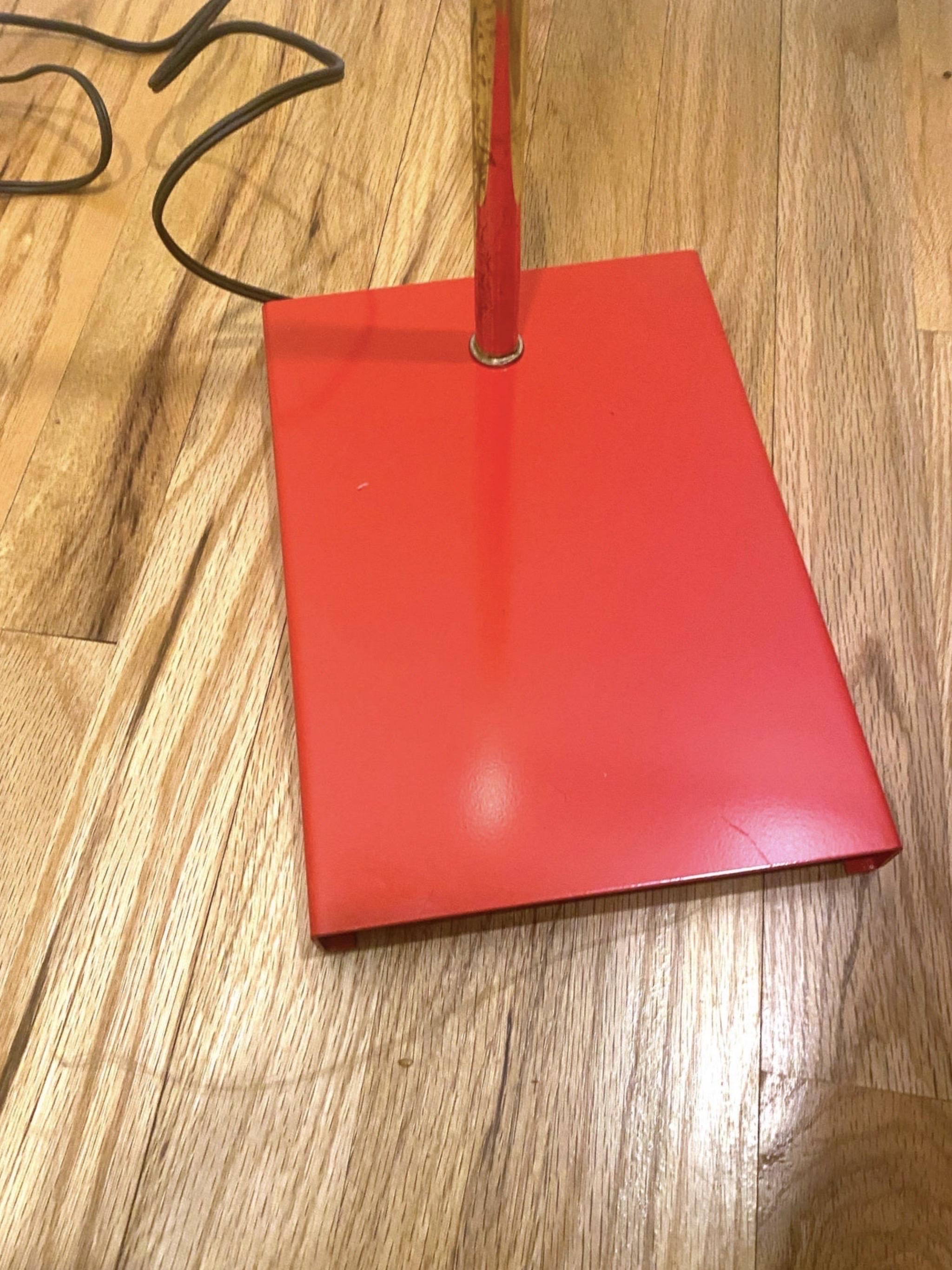 This bright red floor lamp has an adjustable height, perforated bullet shade that swivels 360, brass toned metal body and bright red enamel rectangular base. This has American wiring and is much like a pharmacy lamp, but the coolest pharmacy lamp