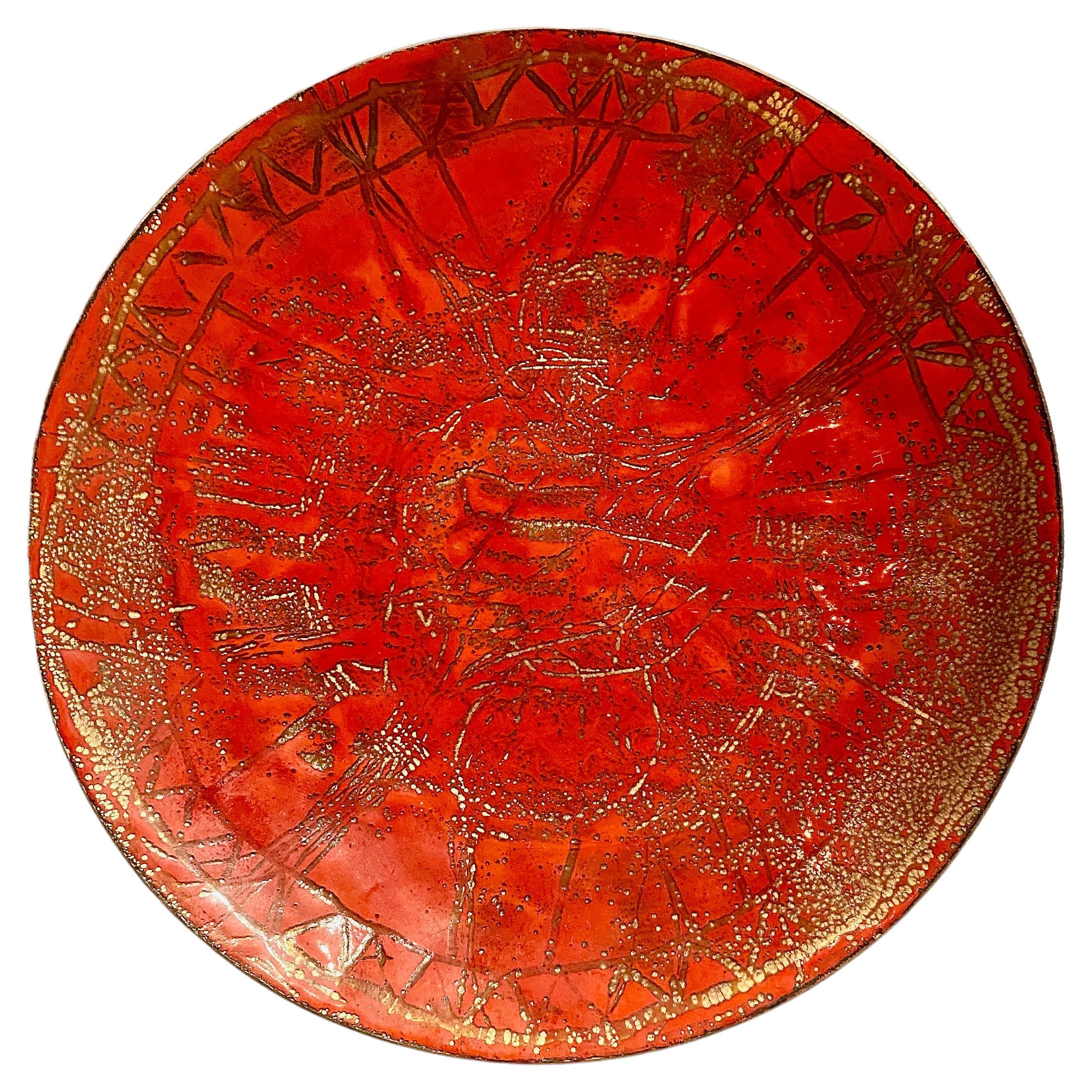 This is a stunning example of a mid-20th century enamel-on-copper vide-poche or catchall. The intense red of the enamel is detailed with abstract graphic designs and is further enhanced by a multitude of tiny bubbles creating several levels of light