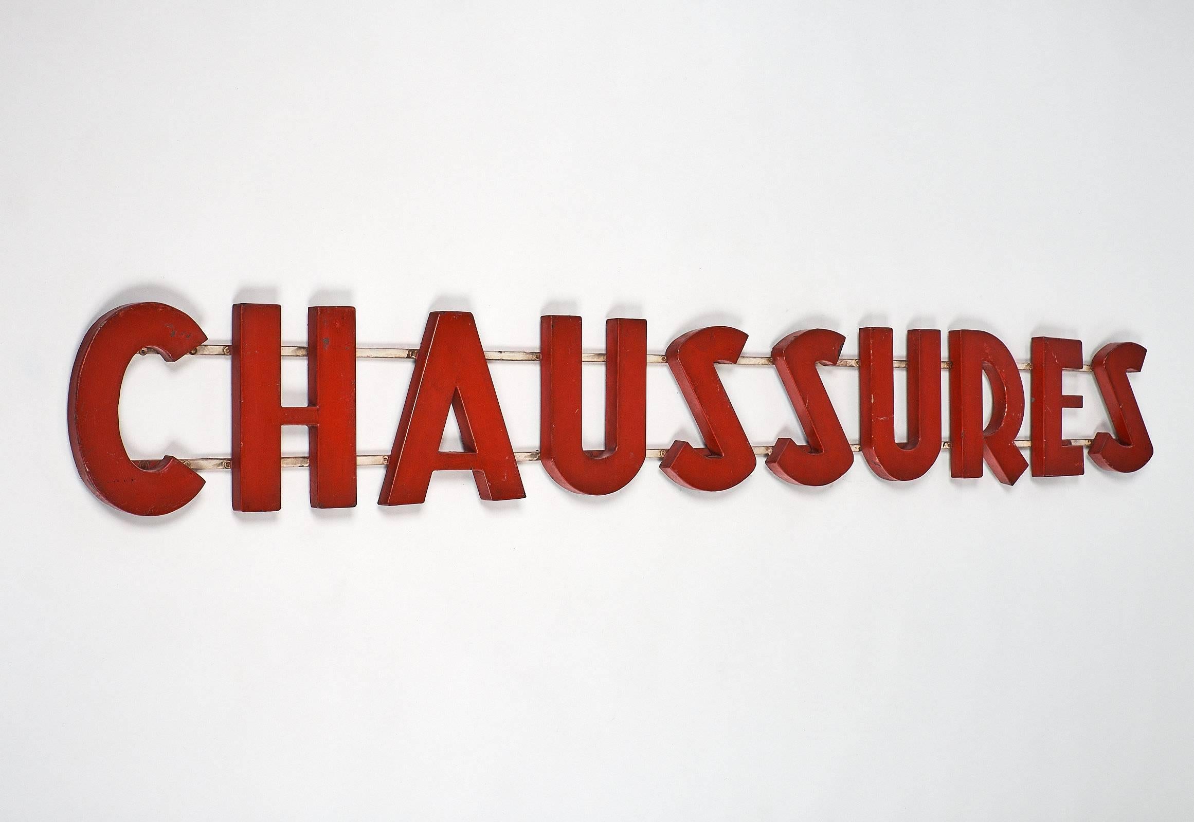 Fun French vintage store sign made of painted metal. We loved the striking red color of this authentic sign. The word “chaussures” means shoes in French.