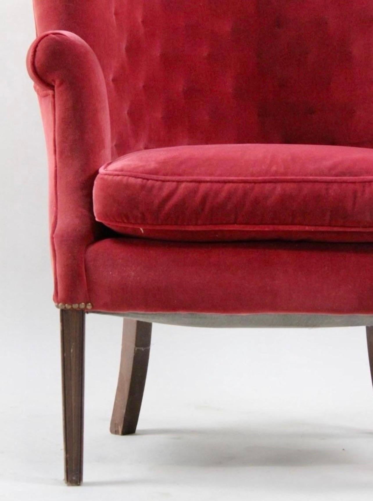 Midcentury wingback chair with vibrant red velvet upholstery. This chair becomes an instant focal point, adding a pop of color and a touch of luxury to your space. The Classic wingback design offers both style and comfort, providing a cozy and
