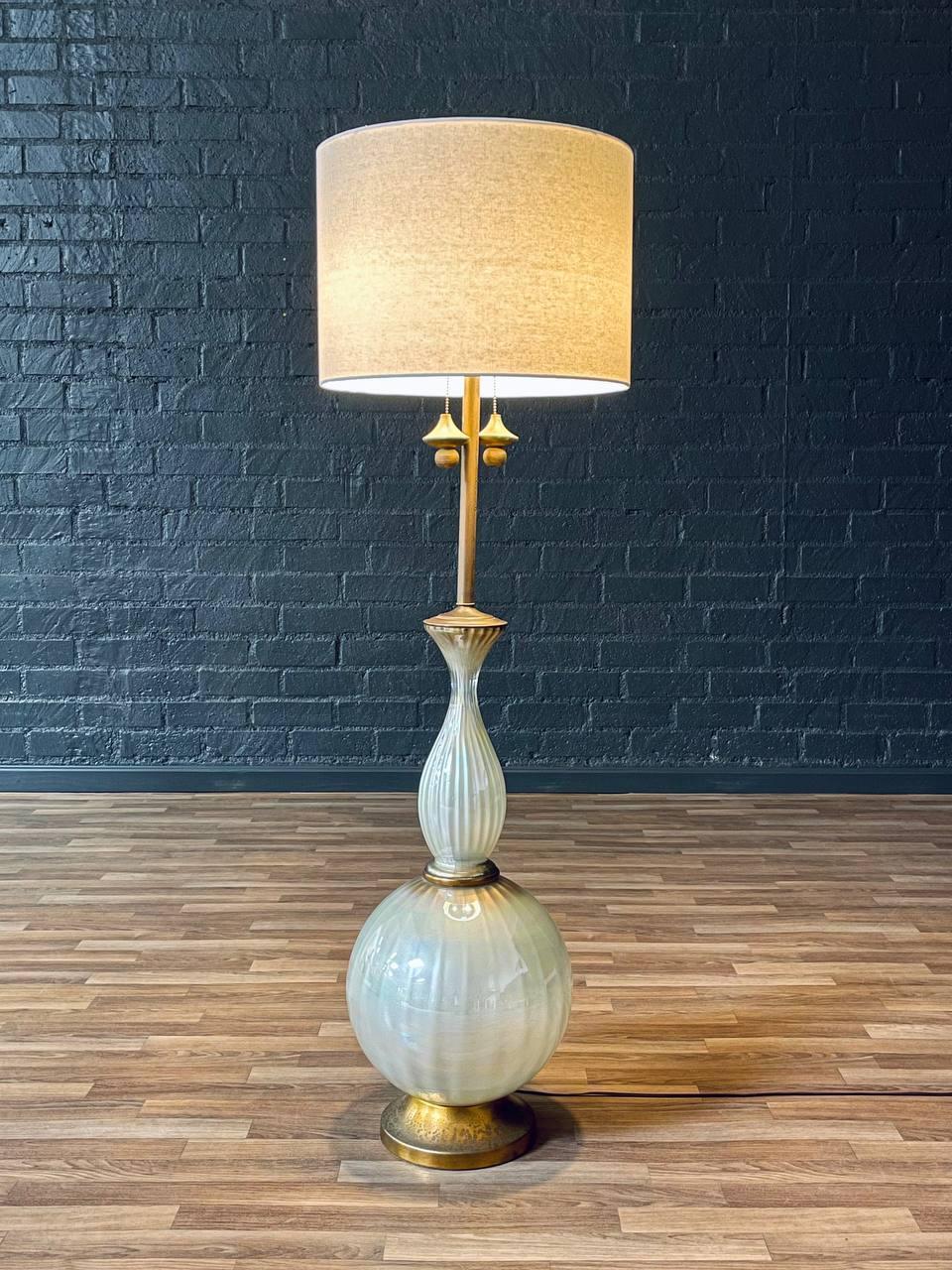 Condit : Nouveau câblage, nouvel abat-jour en lin.
MATERIAL : Verre peint à l'envers, base en métal doré, abat-jour en lin neuf

Ce superbe lampadaire du milieu du siècle dernier, fabriqué dans les années 1950, présente un corps en verre peint