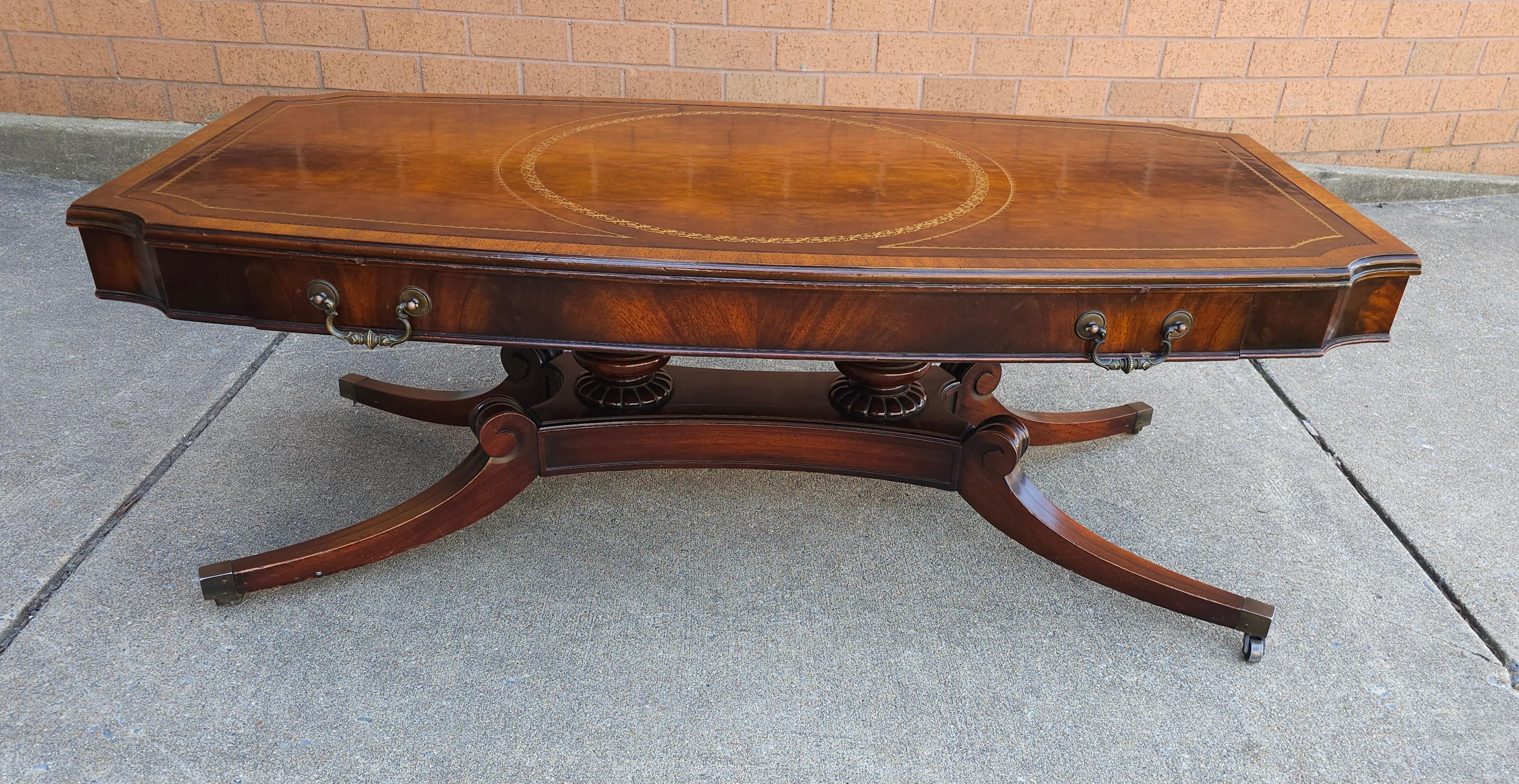 A Mid Century Regency Hollywood Mahogany Inset Leather Top Coffee Table with protective glass top. Measures 46