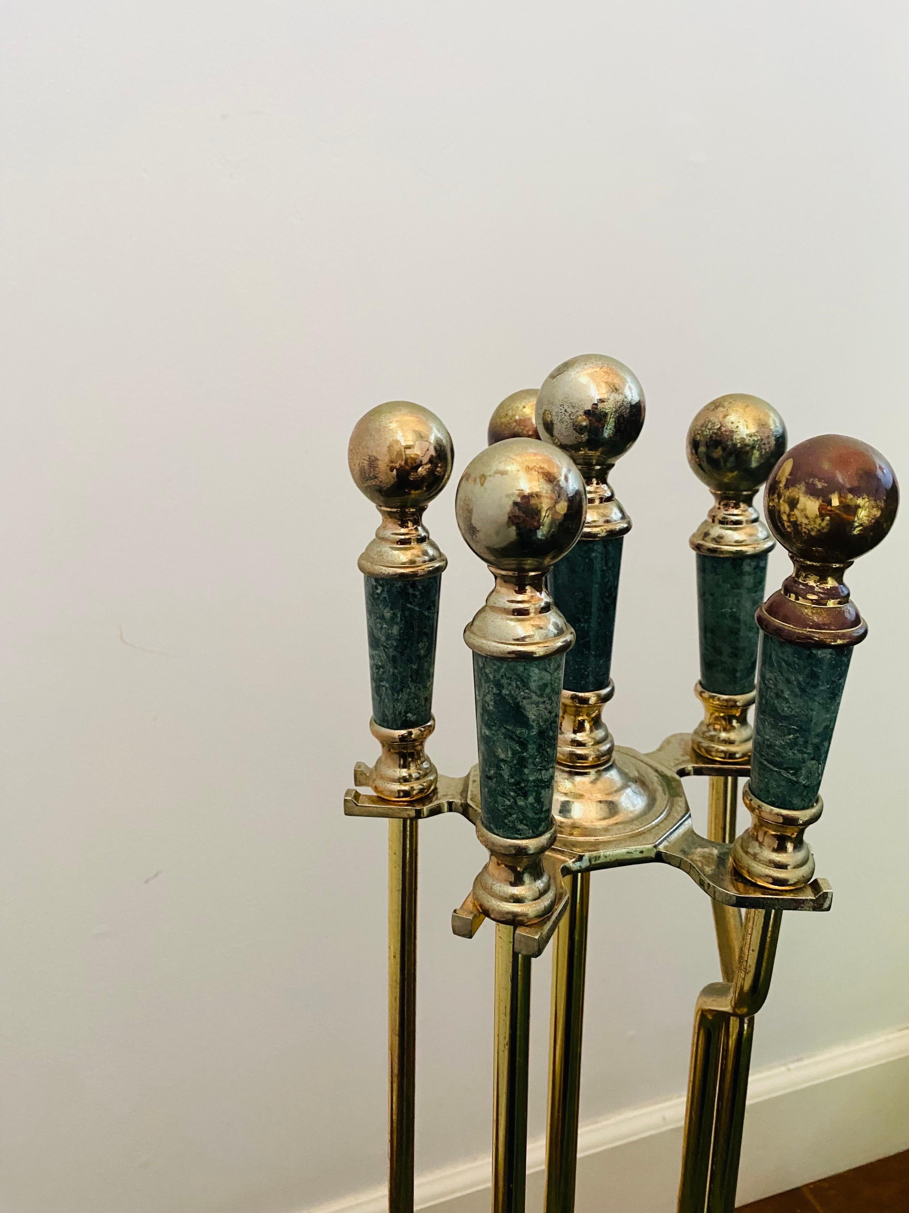 Incredible set of 5 Mid Century Regency Style Brass and Green Marble Fireplace tools.  Elegant slim design that alludes to the glamour of Hollywood Regency style. The streamlined tools line up and elongate adding visual elegance as they rest in a