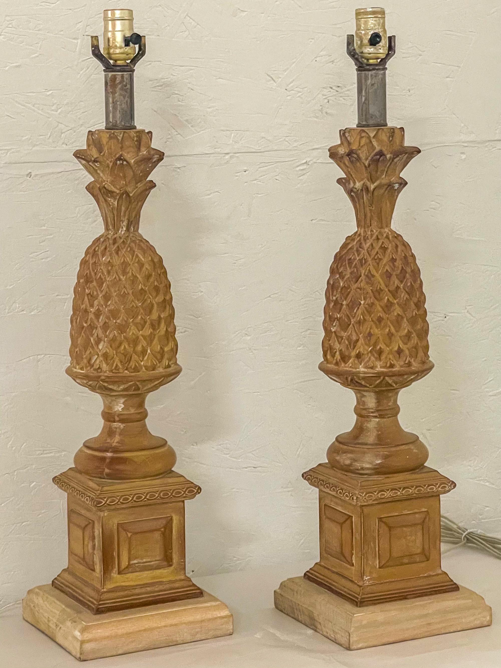 This is a pair of mid-century regency style carved and cerused pineapple lamps attributed to Chapman. They are in working order, and it is 22” to the top of the wood.