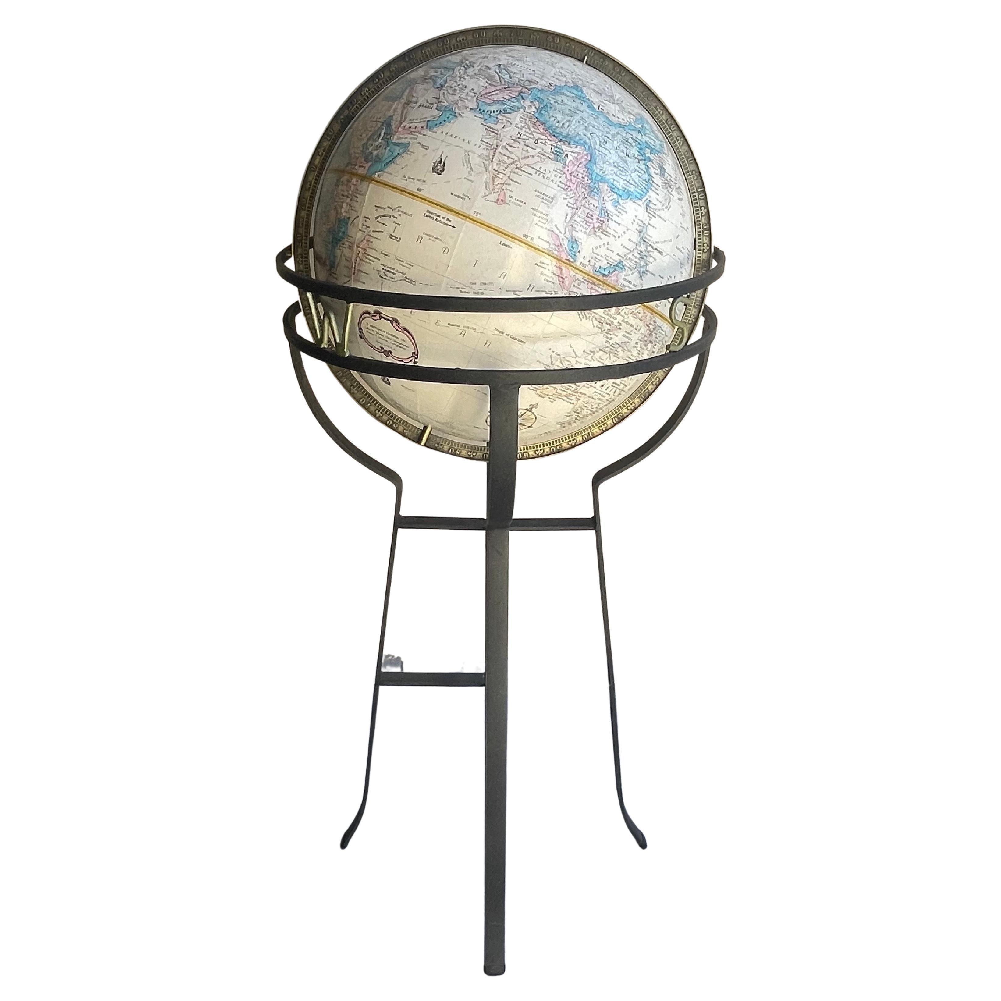 Mid-century Replogle globe on wrought iron base (N,S,E,W represented on stand) in the manner of Paul McCobb, circa 1960s. The globe is in good condition and measures 17