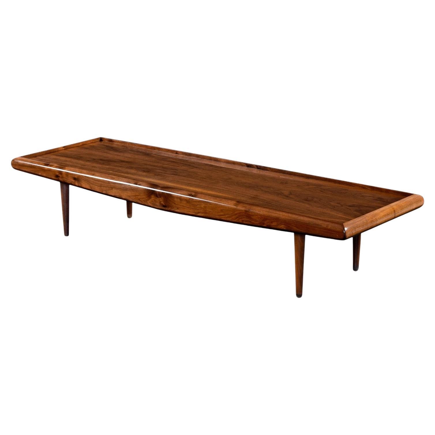 The fiery cathedral grain top of this captivating coffee table is recessed and framed out by solid walnut beams with burl accents. The front and back cross beams of walnut have a slight taper towards the ends to emphasize the look of winged flight.