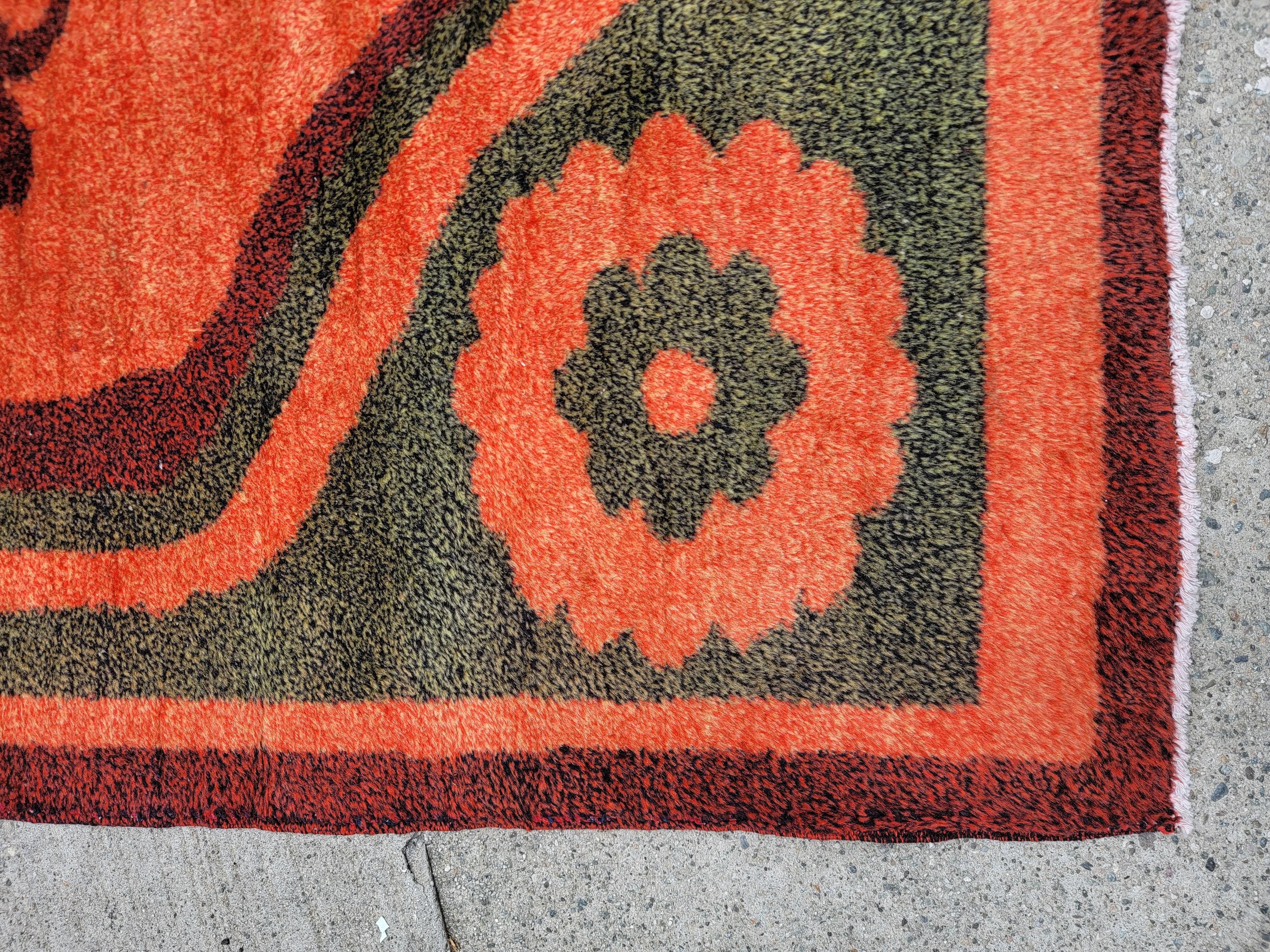 Midcentury Retro European hand Made Rug with a beautiful orange and green floral design. 4 contained flowers in the corners containing the inner larger flower. Goes amazing in a modern or Scandinavian inspired look. 

 4ft wide x 7 ft long.