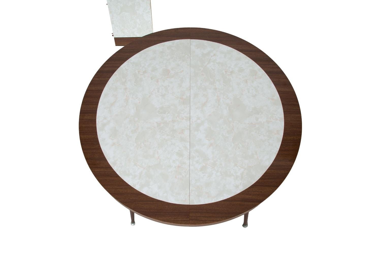 Stunning Vintage Mid Century circular laminate and metal expandable table. Features a smooth white laminate surface accented with a brown edge, raised over four stylish metal legs. This beautiful table comes with one extension leaf to accommodate