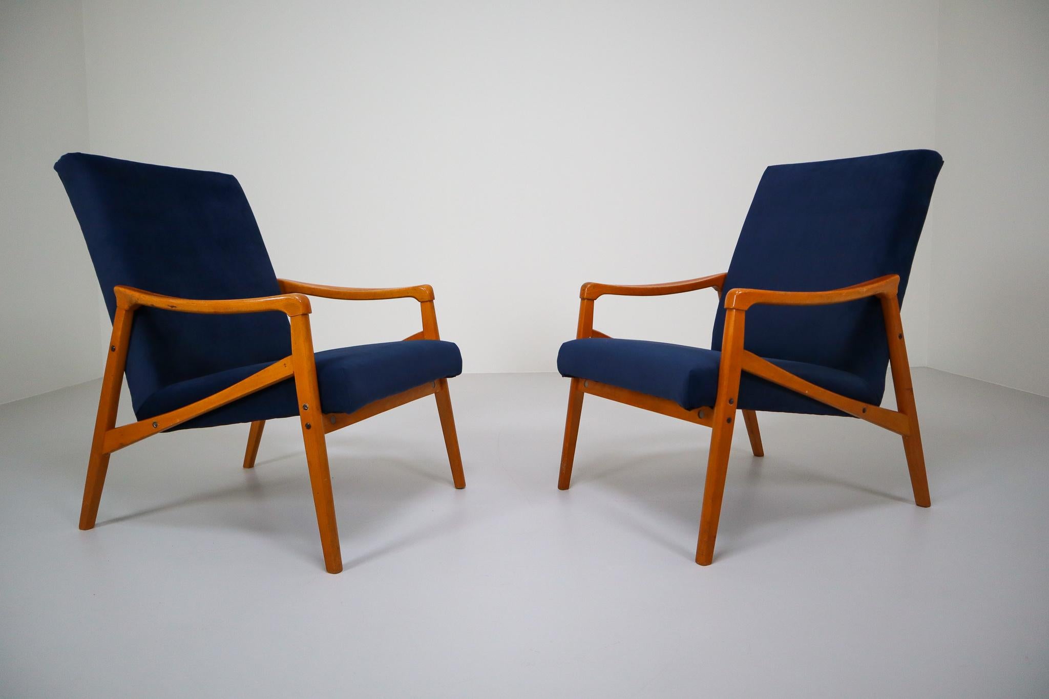 Pair of original vintage midcentury armchairs / lounge chairs manufactured and designed in Czech Republic, 1970s. Made of beechwood and professionally reupholstered in blue velvet. These armchairs would make an eye-catching addition to any interior